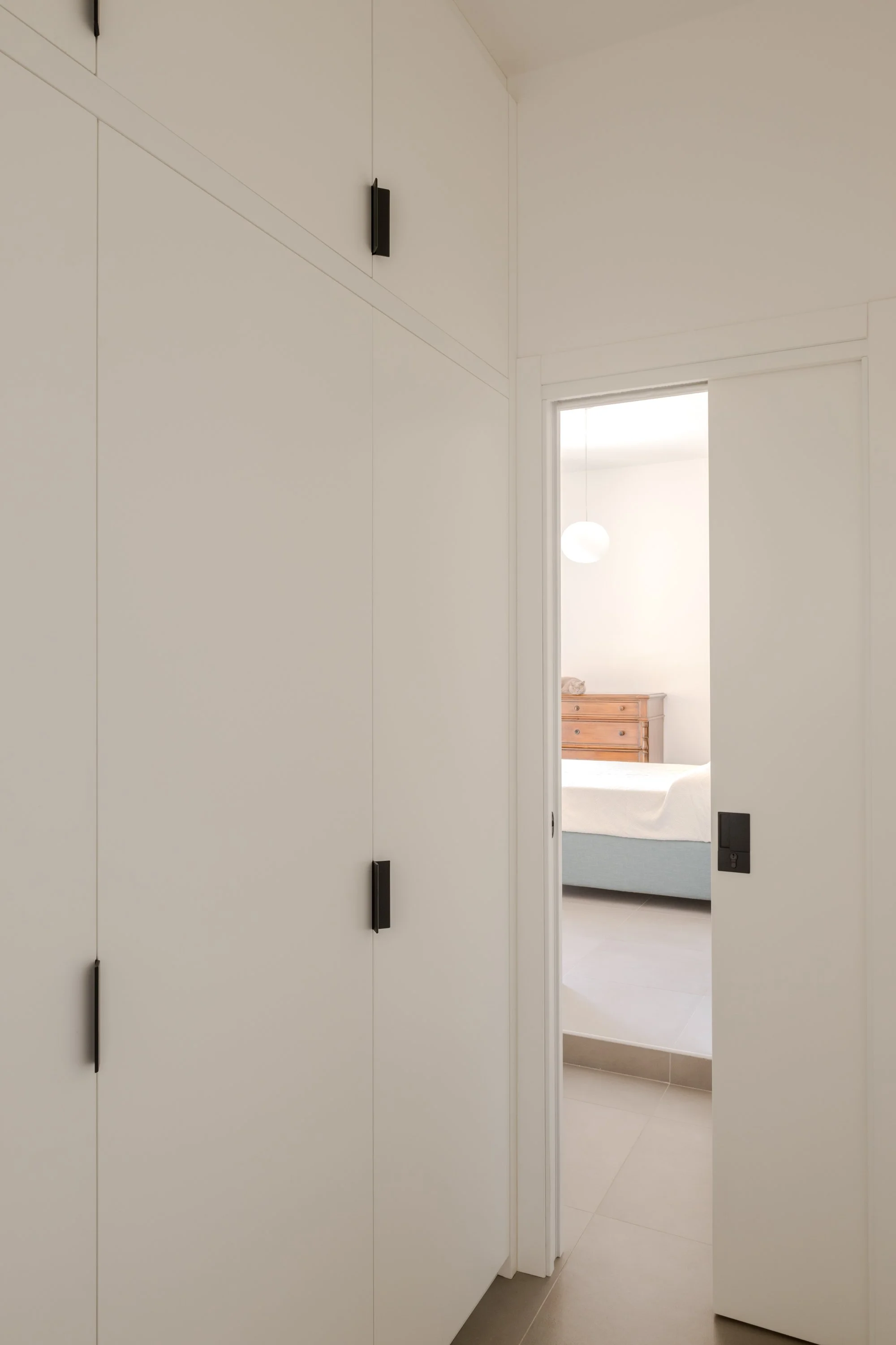 Porta scorrevole a scomparsa tra corridoio e camera da letto in appartamento ristrutturato a Palermo.