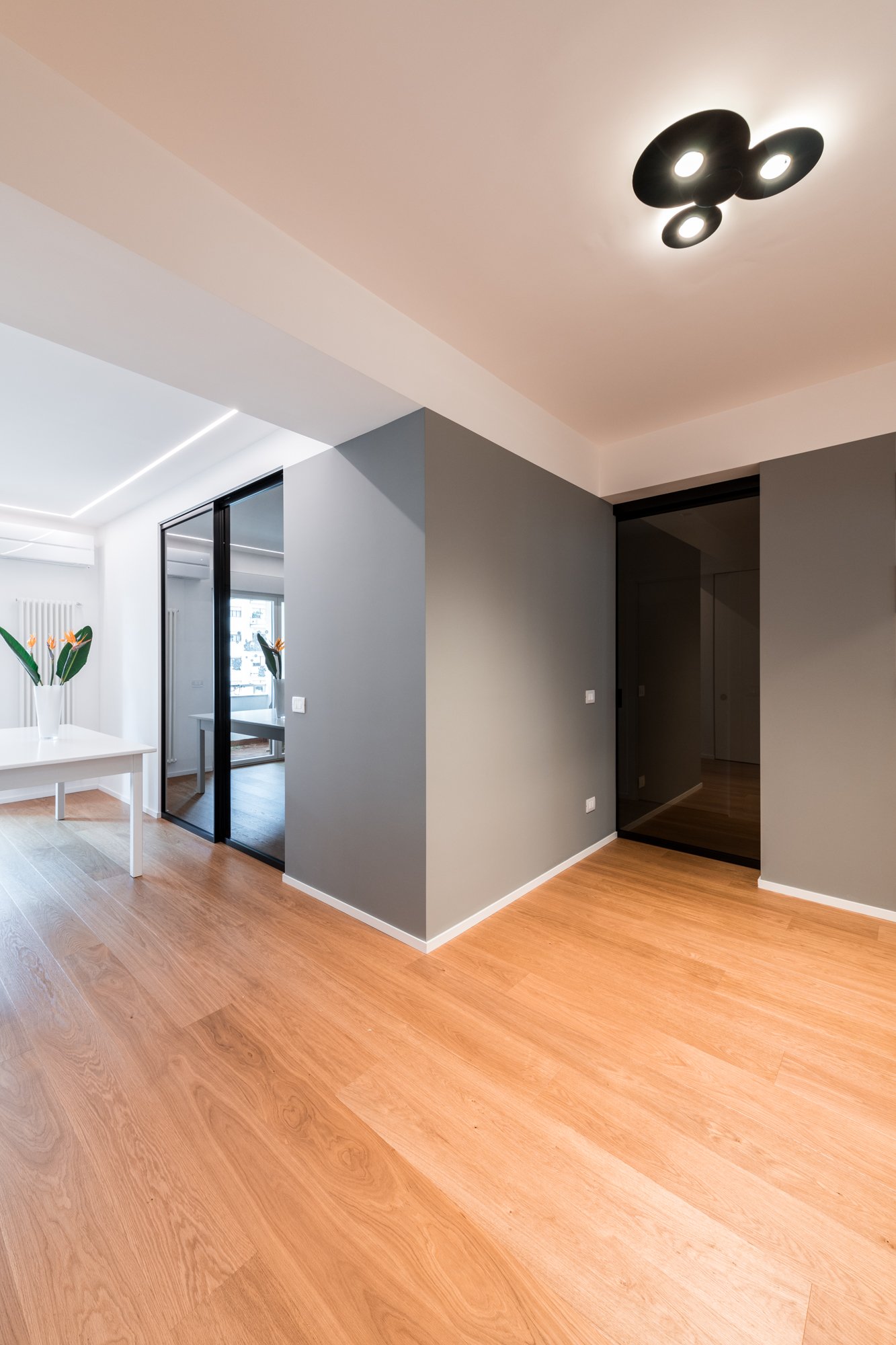 Il dispositivo di progetto ed il rapporto con il parquet rovere di Listone Giordano e le porte a vetri scorrevoli.