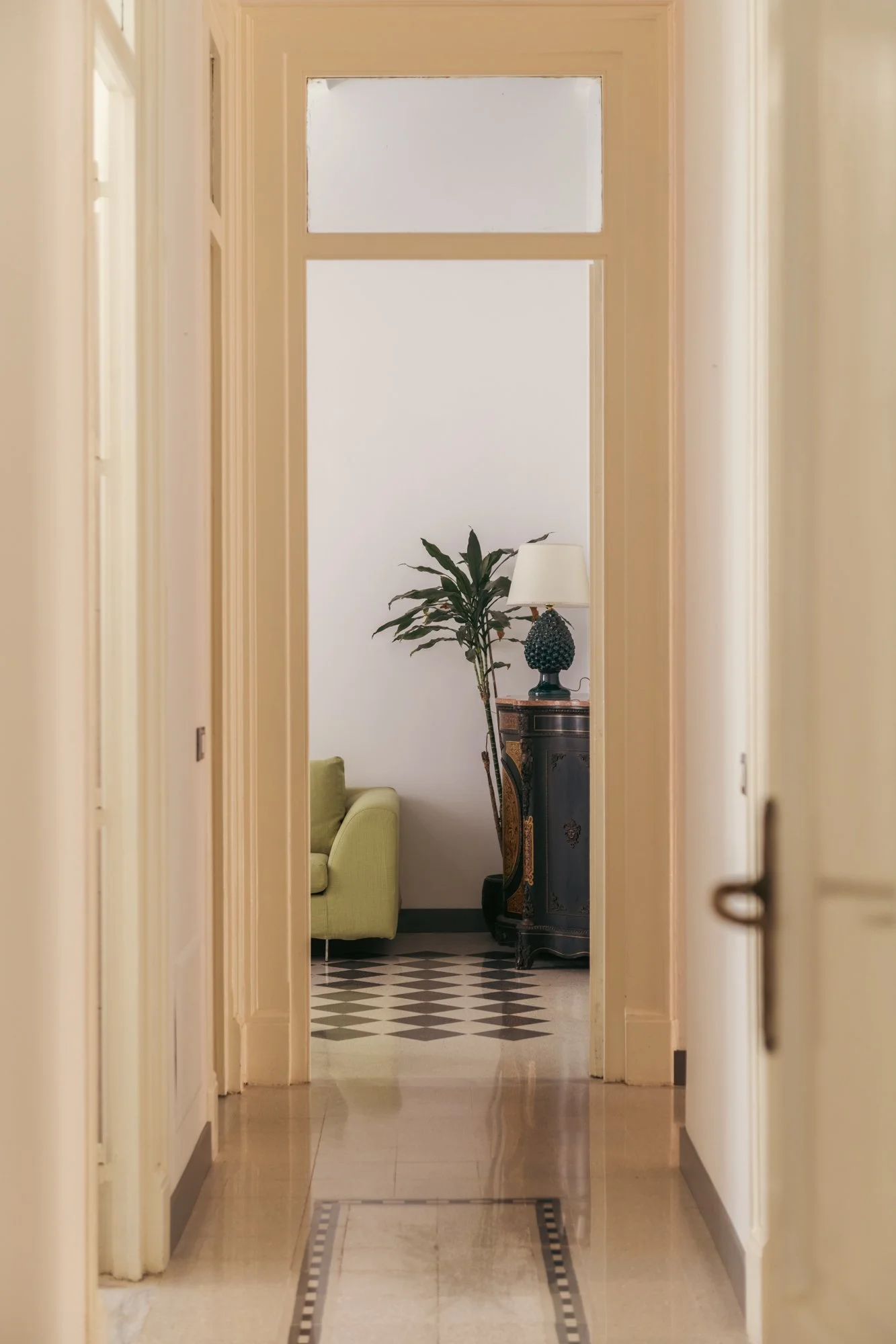 Le aperture storiche dell'appartamento a Palermo inquadrano una sequenza di ambienti che conserva il carattere originario della casa, reinterpretato attraverso il progetto di restauro.