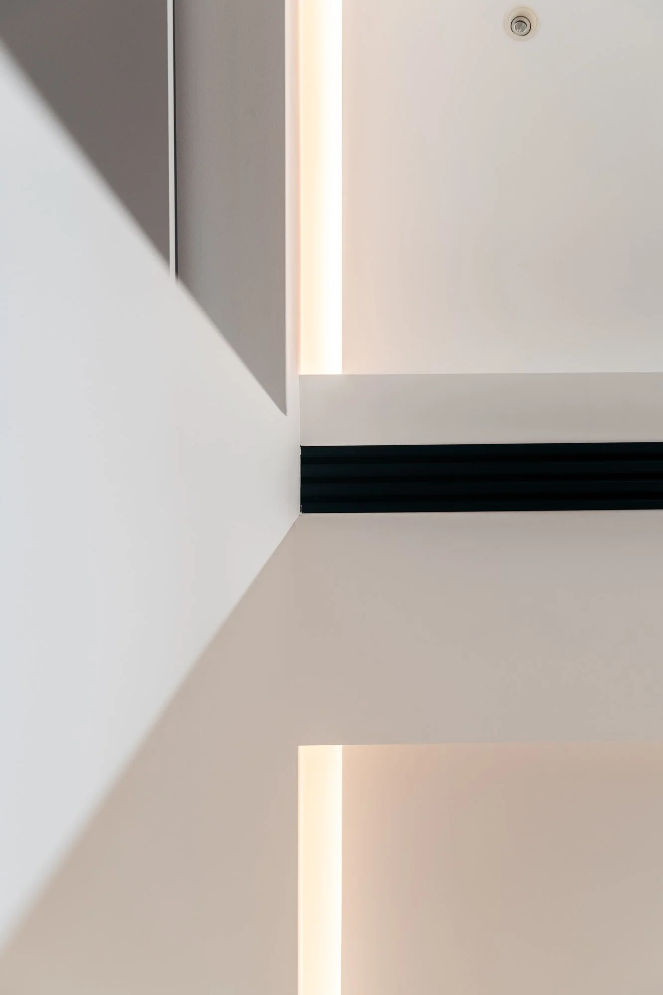 Le linee architettoniche e la luce integrata dell'appartamento a Palermo enfatizzano la percezione dello spazio e la continuità tra gli ambienti.