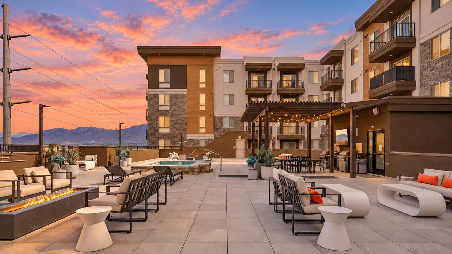 Sunset over the rooftop deck with lounge area, fire pit and hot tub. 
