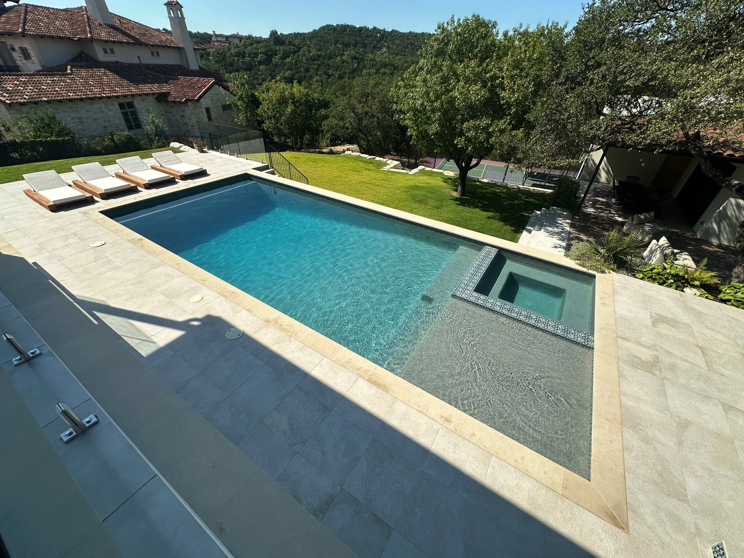 Aerial view of a modern luxe pool and spa overlooking the Austin Hill Country