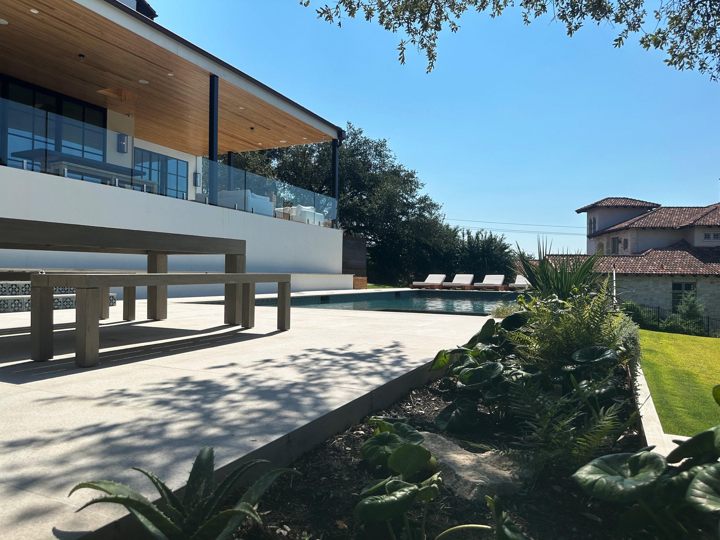 Buff Lueders stone patio and dining bench beside a modern luxe pool in the Texas Hill Country