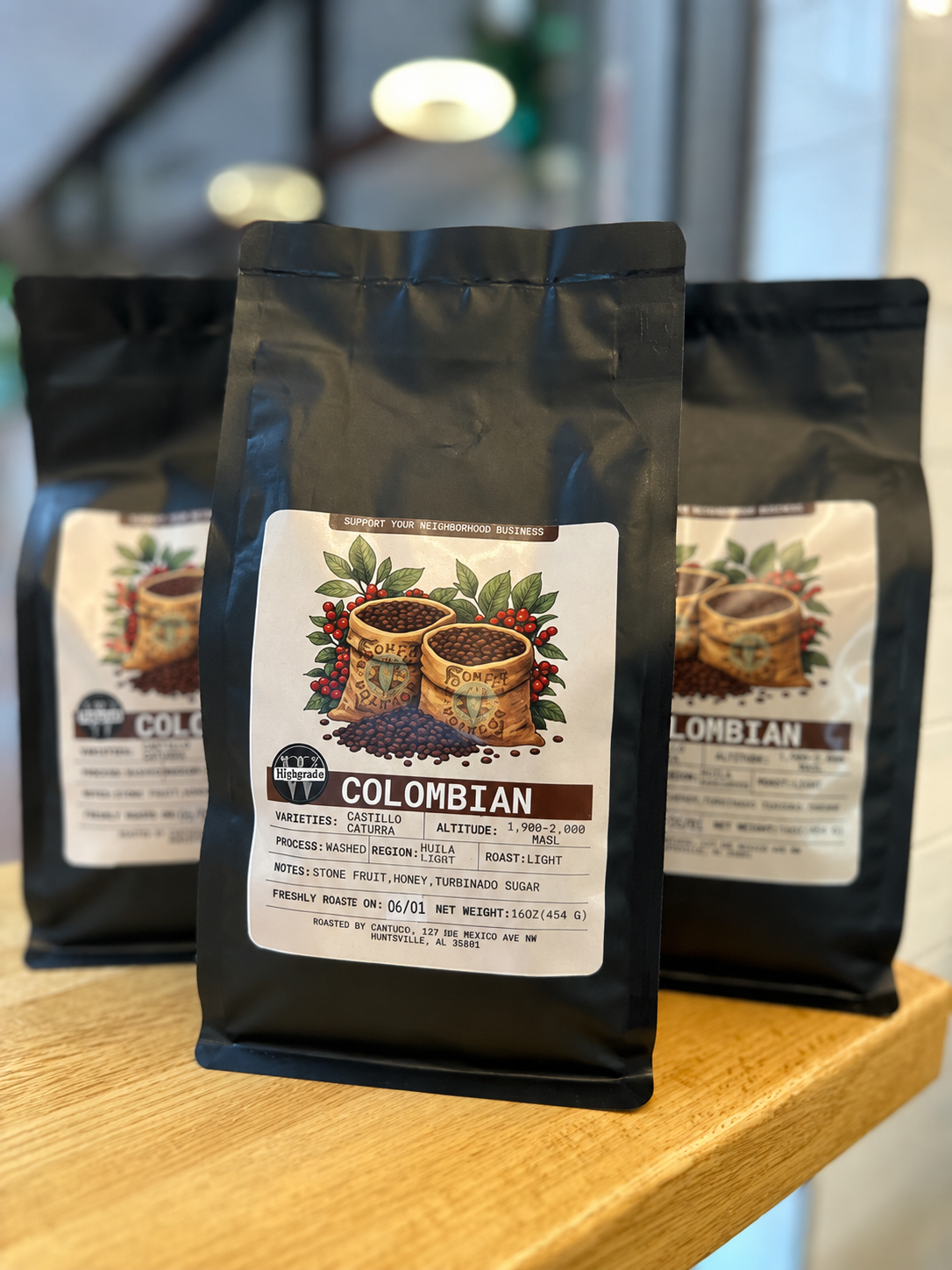 Cravings Washington DC - Three bags of Colombian coffee beans on a wooden surface, with the front bag labeled with details including variety, region, and notes.