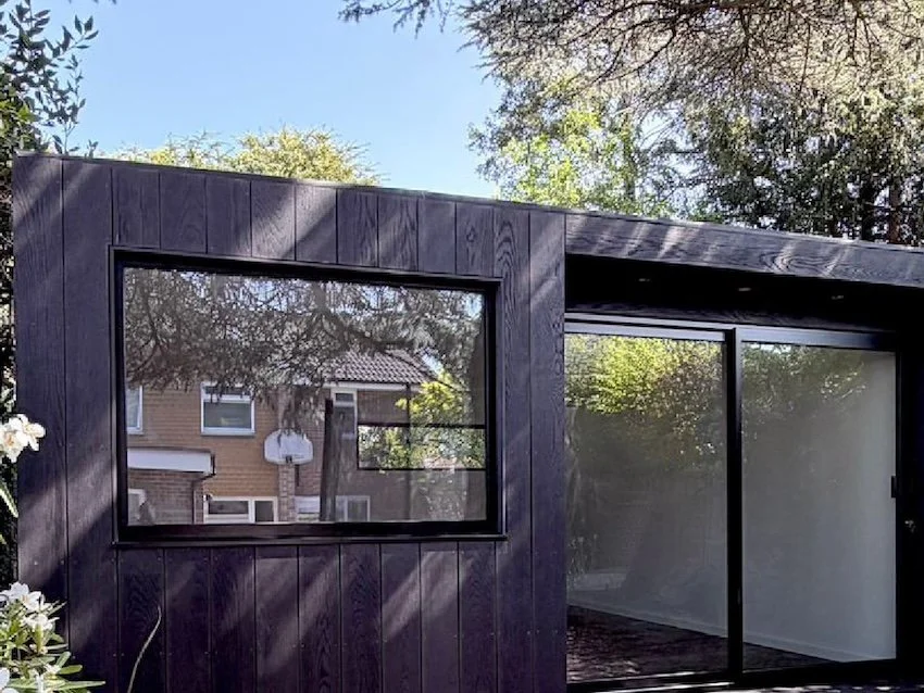 Bespoke black garden room finished with Millboard cladding.