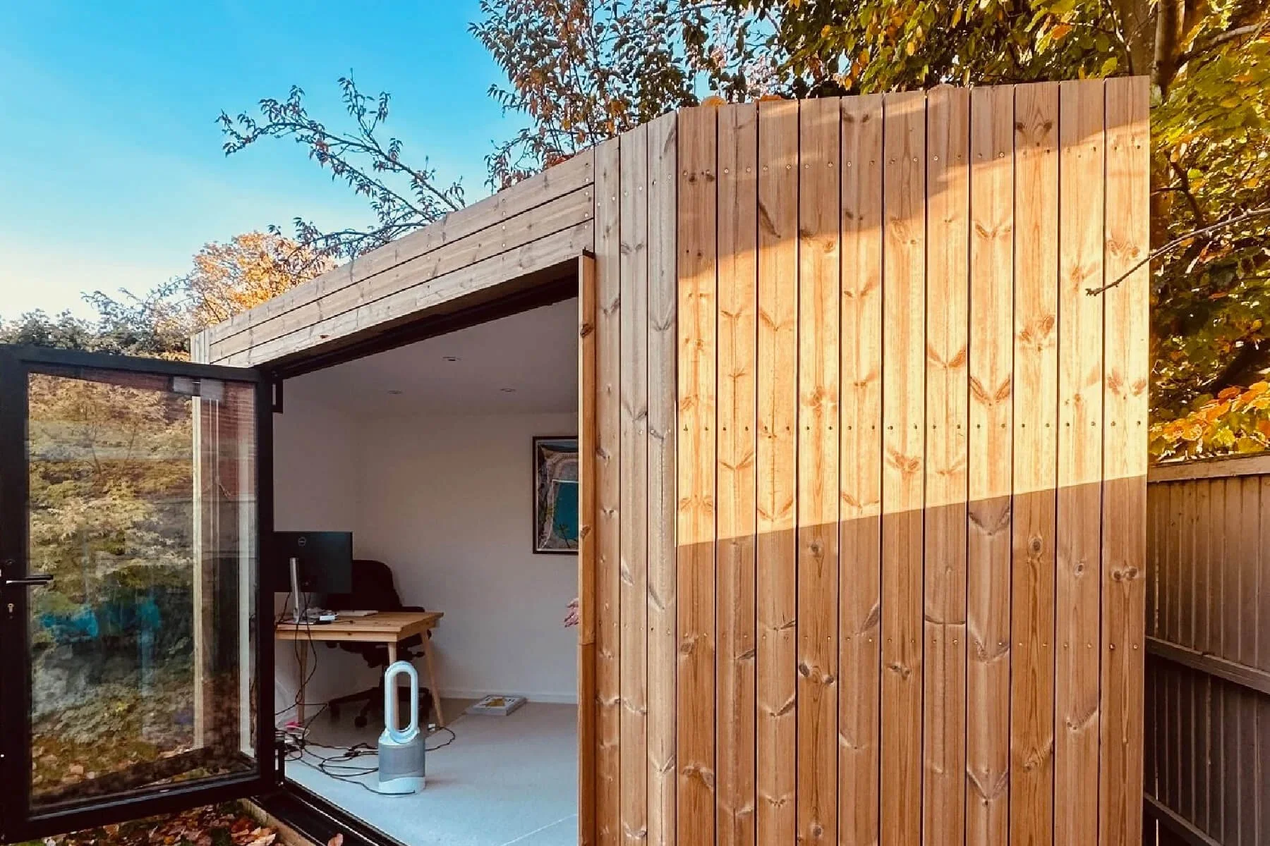 Garden room exterior finished with Thermowood cladding, showing natural timber finish and open sliding doors