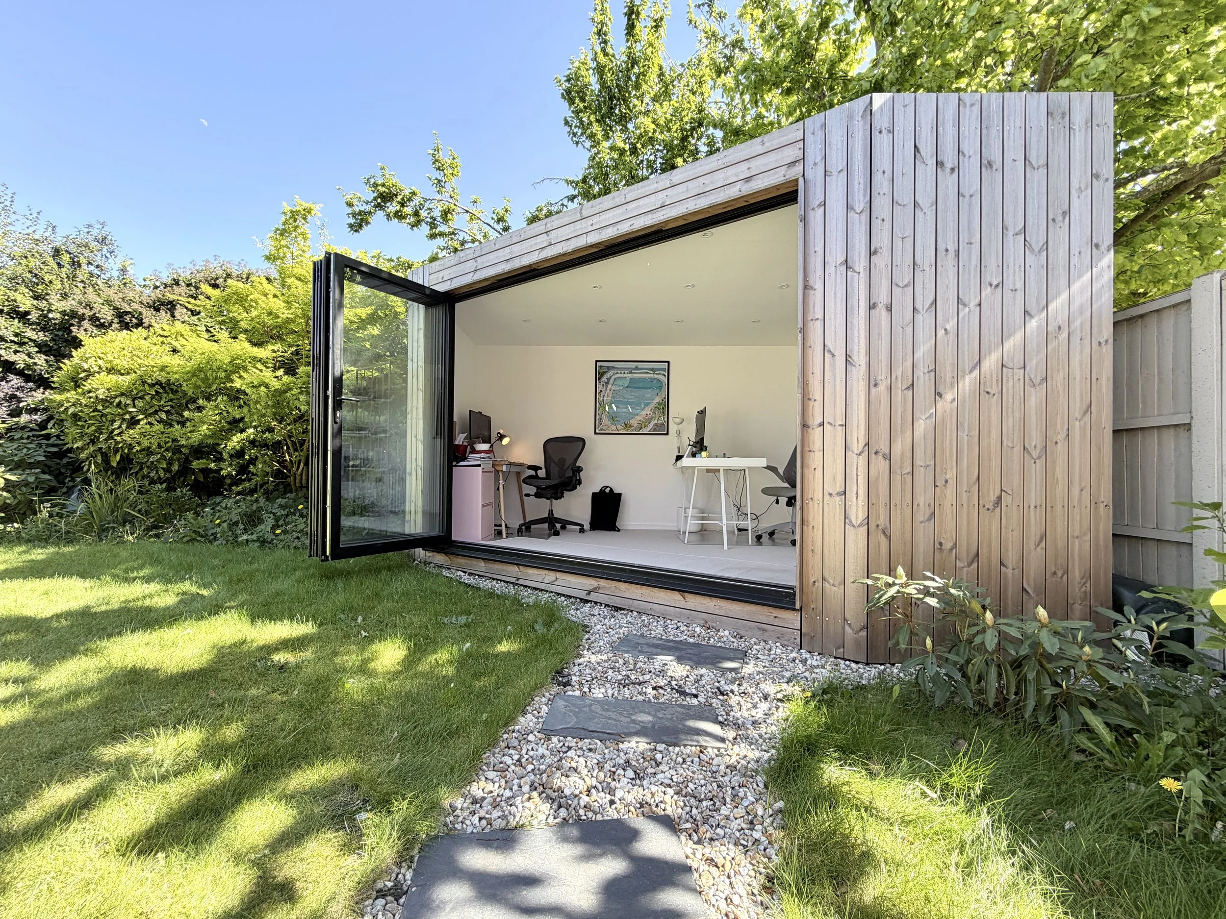 Bespoke corner garden office with bi-fold doors open to a bright, fully finished workspace