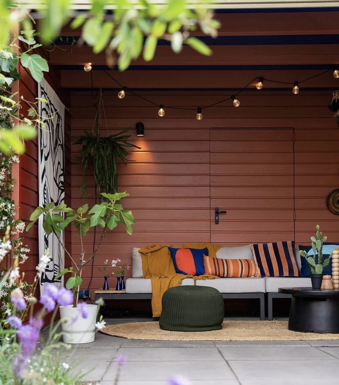 Open garden room with covered seating area and ambient lighting, designed for comfortable outdoor use