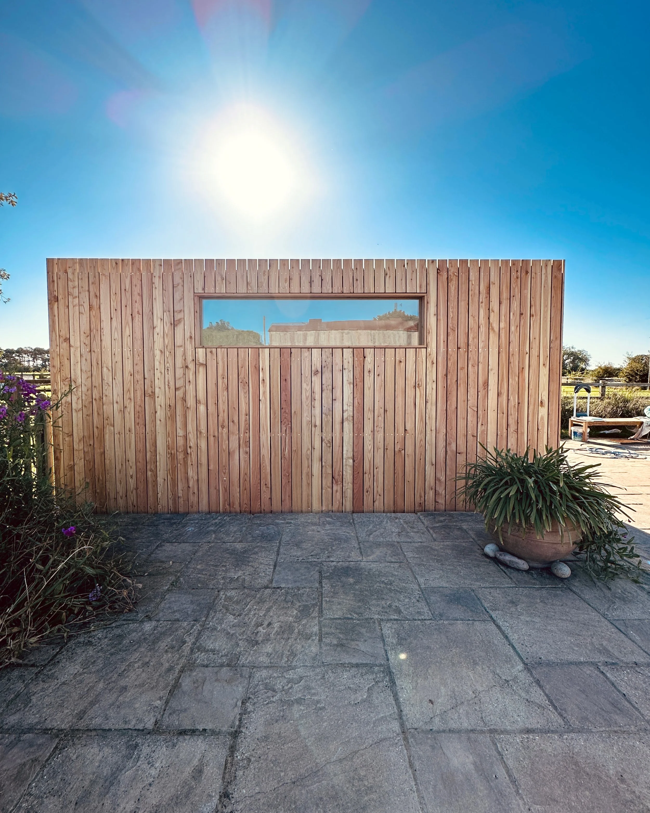 Side view of the FORZA garden room showing external cladding and a high-level fixed window for natural light and privacy