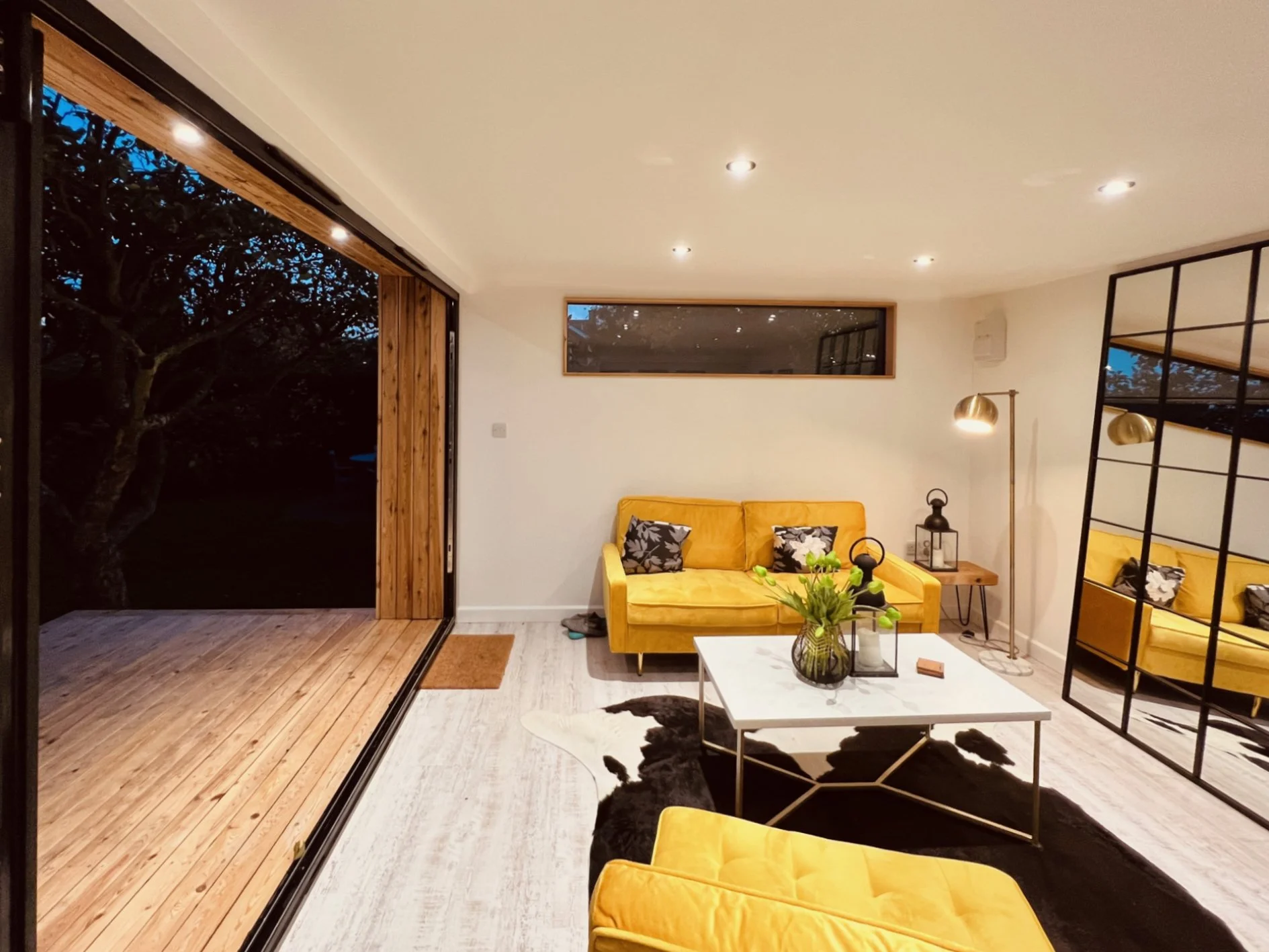 Garden room interior used as a comfortable multi-purpose space with lighting for evening use