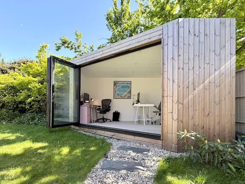 Bespoke angled corner garden office designed to fit the available space, with three-metre bi-fold doors.