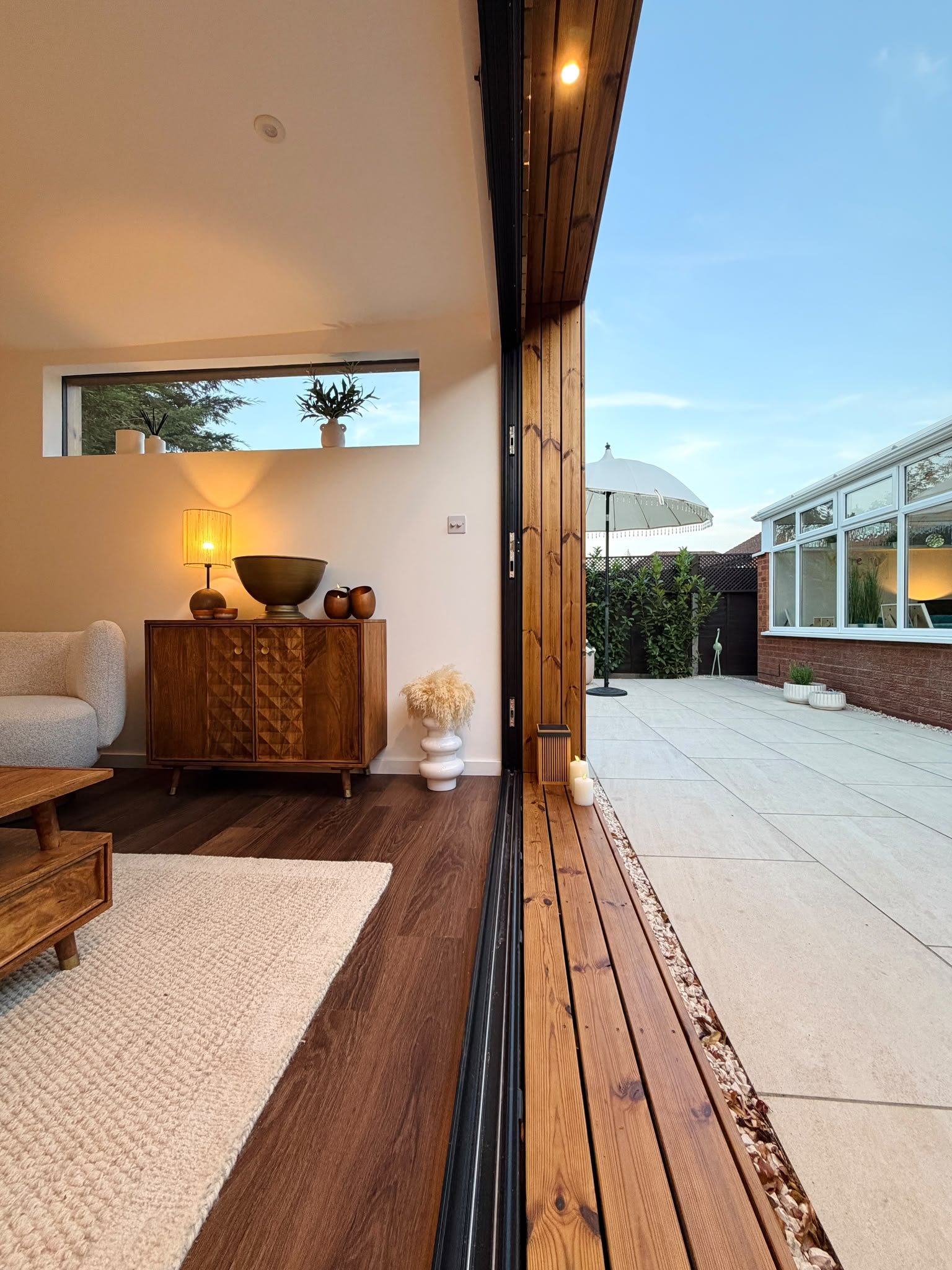 Contemporary garden room interior with bifold doors opening onto a landscaped patio.