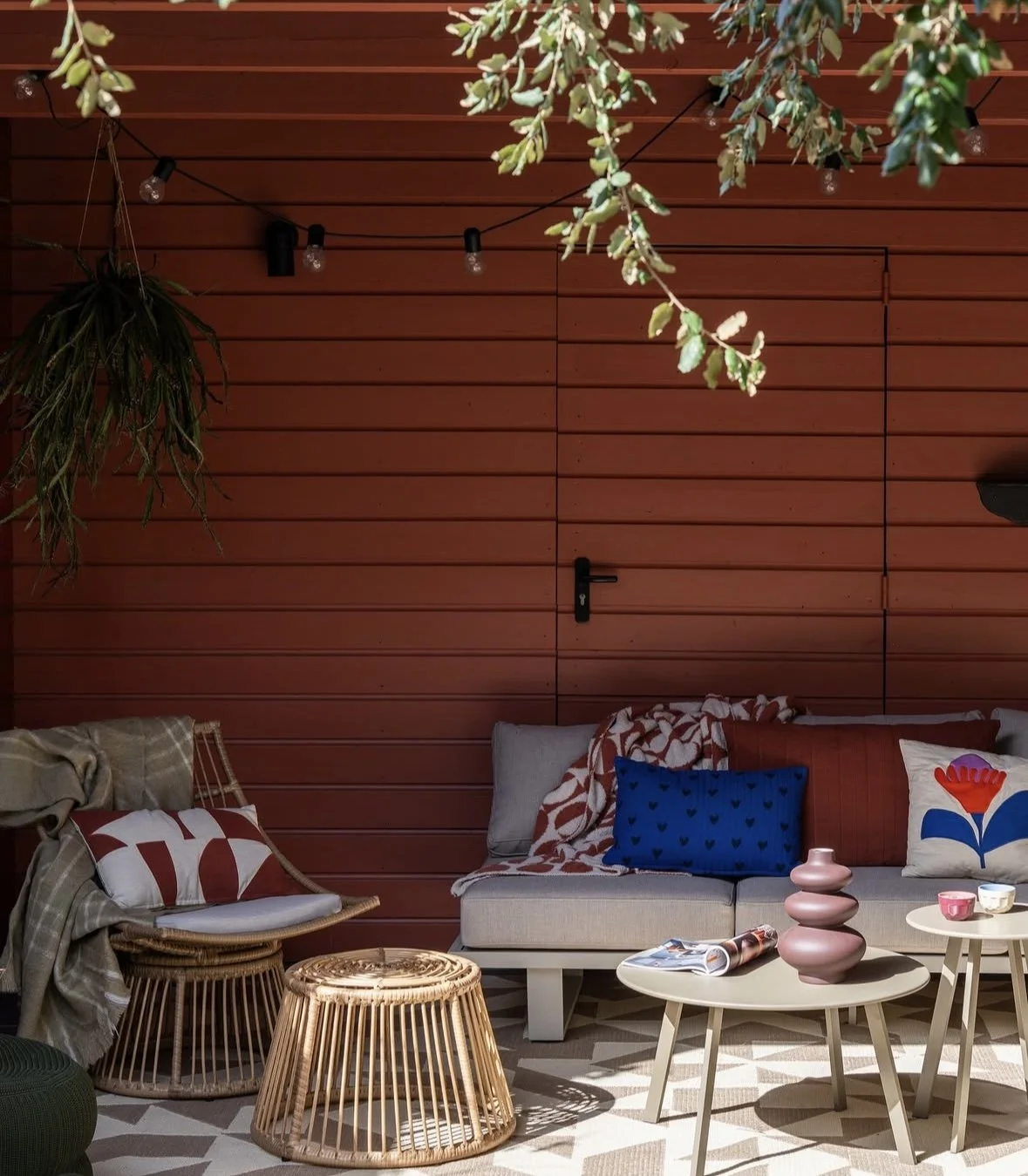 Open garden room with relaxed seating, side table, and sheltered outdoor layout