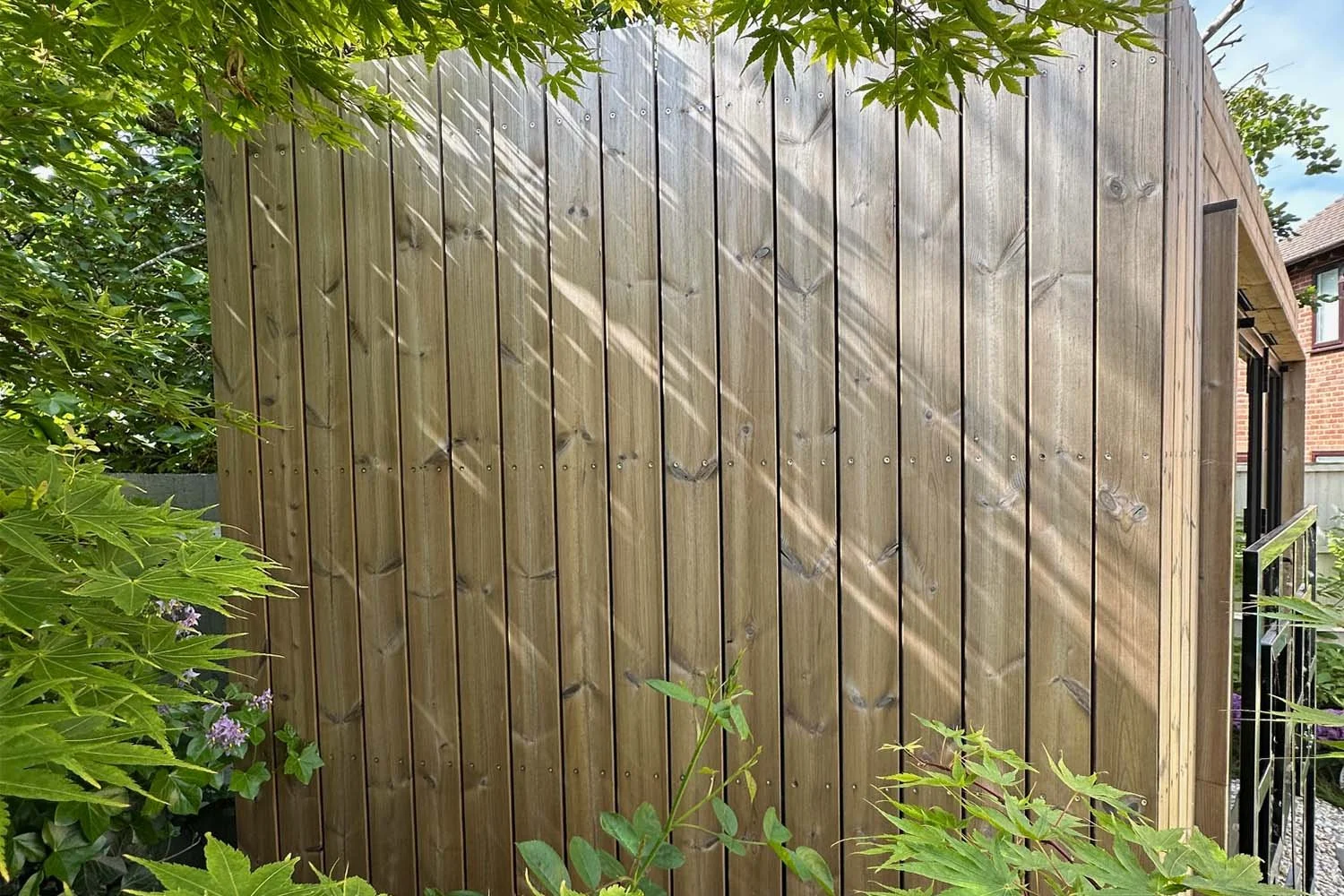 Timber cladding detail on a garden room in Wiltshire with natural sunlight and shadow
