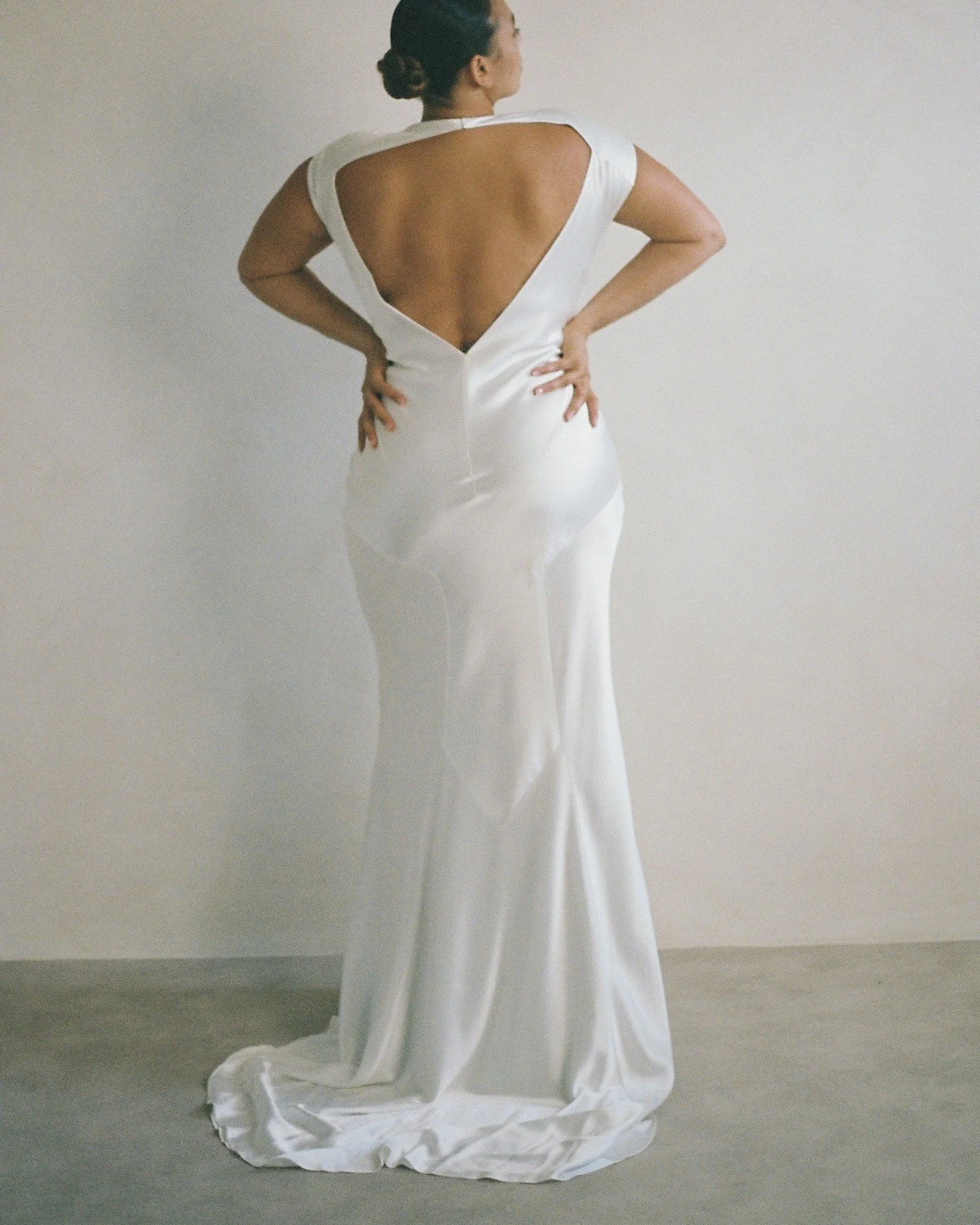 Brides are loving the Beatrice Dress. Meticulously constructed from intricately cut panels of luminous satin, this beauty has a soft high cowl neckline, open back, and strikingly angular darts and seams, precision engineered for a beautifully flatter