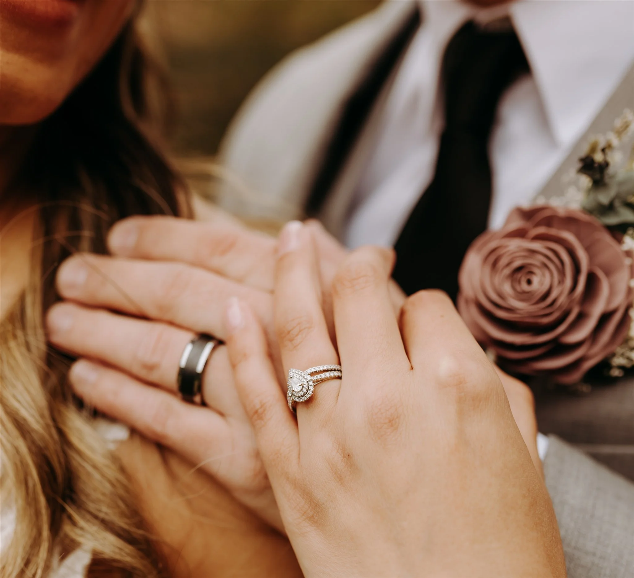Close-up of a woman and a man holding hands, showing wedding rings at Rolla, MO rustic wedding venue, The Village. Photos by Columbia, MO Photographer Liv Strange Photography.