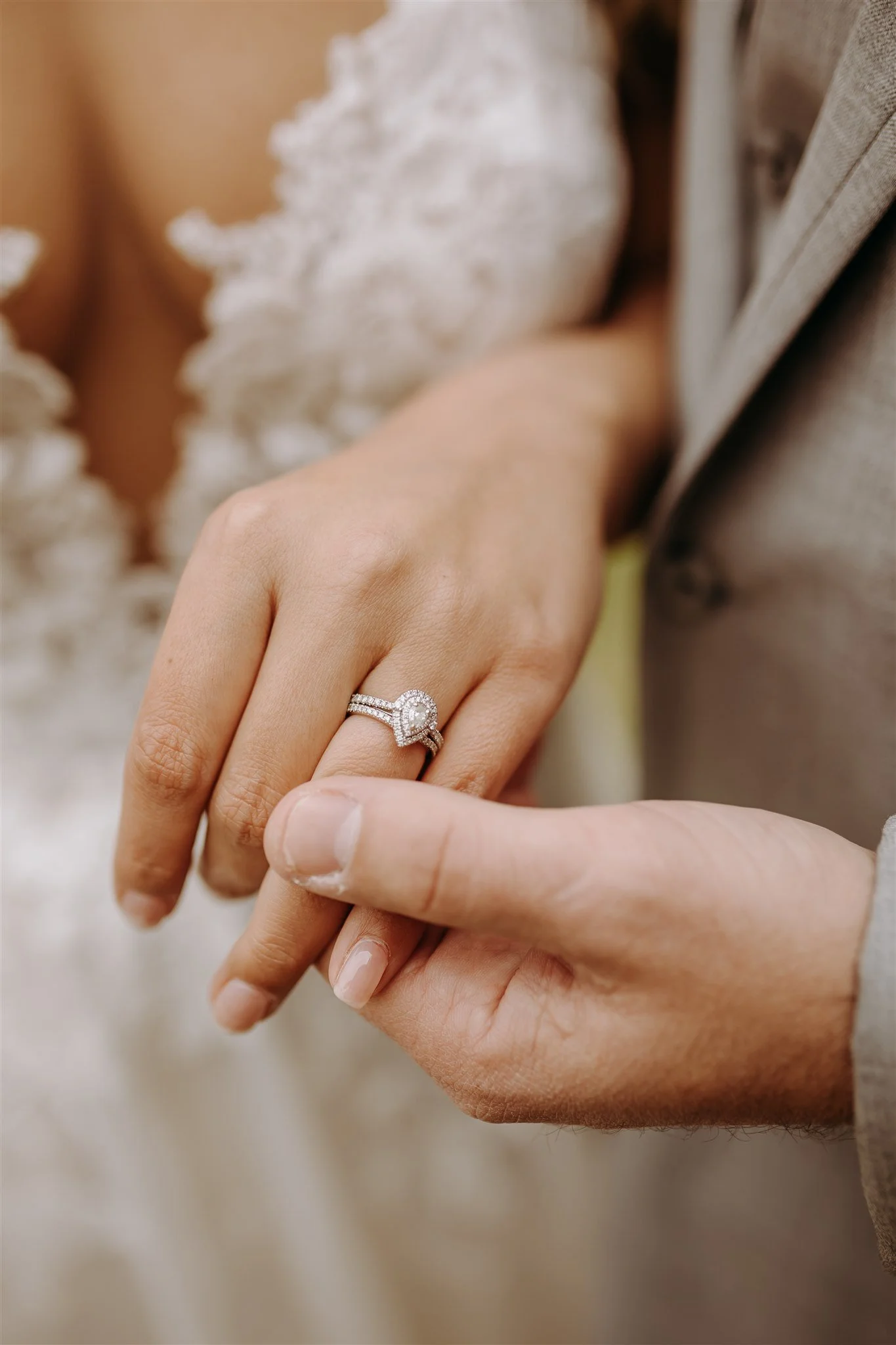 Close-up of a woman's hand wearing an engagement ring with a heart-shaped diamond and a wedding band at Rolla, MO rustic wedding venue, The Village. Photos by Columbia, MO Photographer Liv Strange Photography.