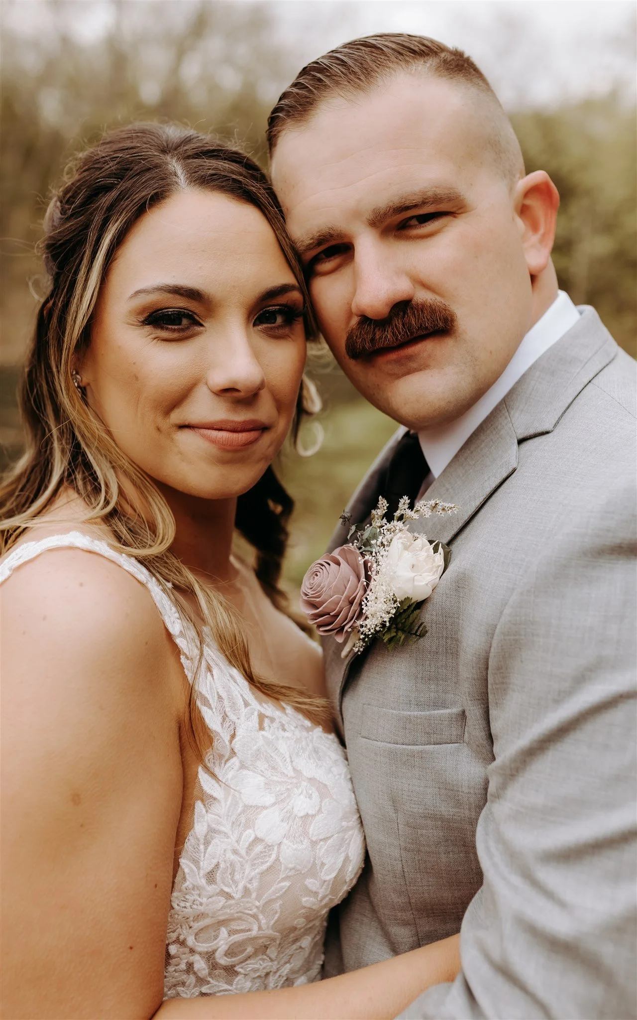 Close-up of a bride and groom on their wedding day. The bride has light brown hair and is wearing a white lace wedding dress at Rolla, MO rustic wedding venue, The Village. Photos by Columbia, MO Photographer Liv Strange Photography.