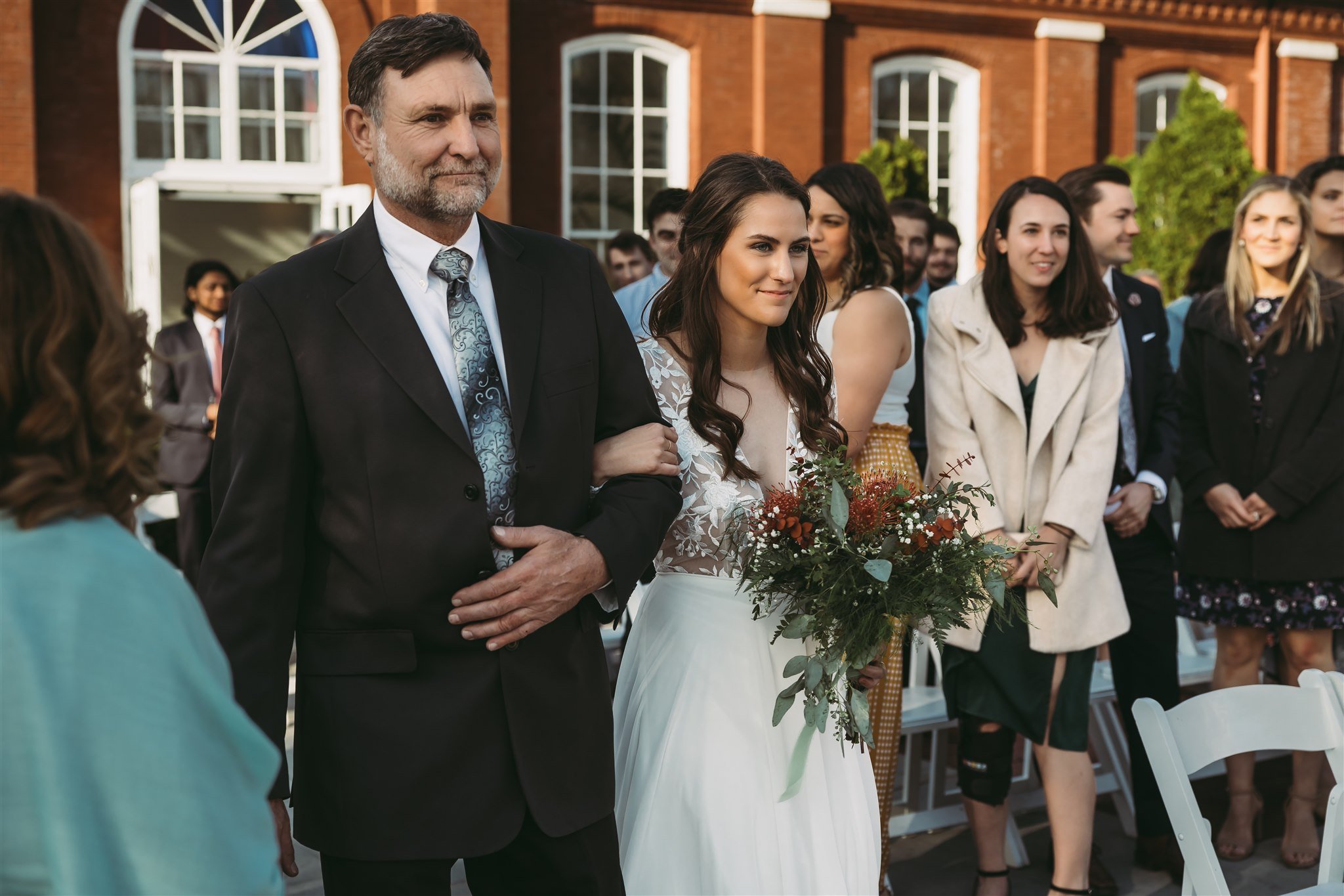 Photo of bride walking down the aisle with her father outside of the Piper Palm House in STL