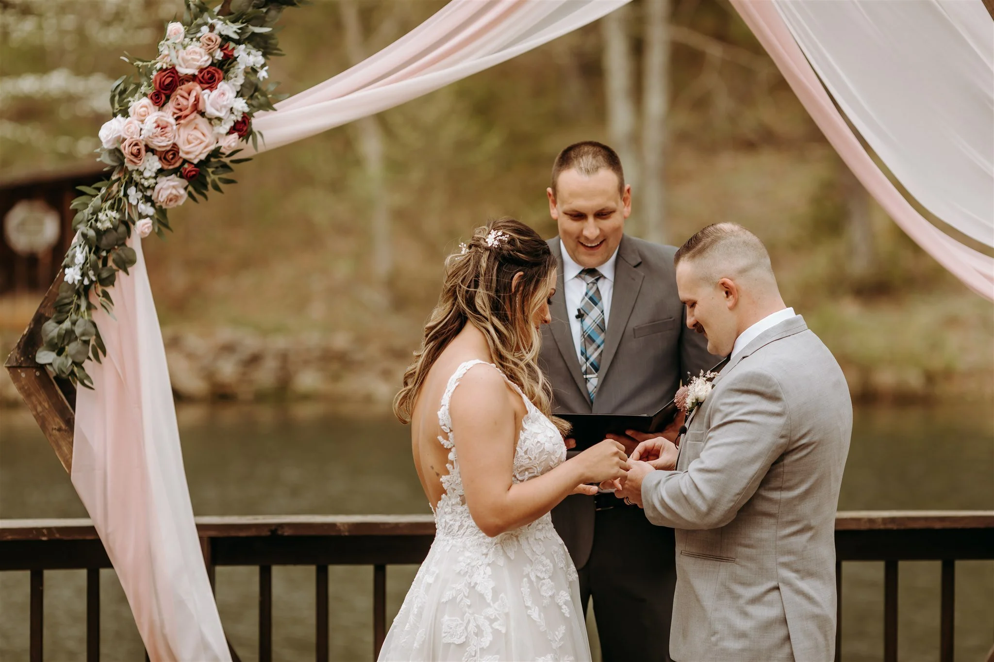 A bride and groom exchanging rings during their outdoor wedding ceremony at Rolla, Missouri rustic wedding venue, The Village. Photos by Columbia, MO Photographer Liv Strange Photography.