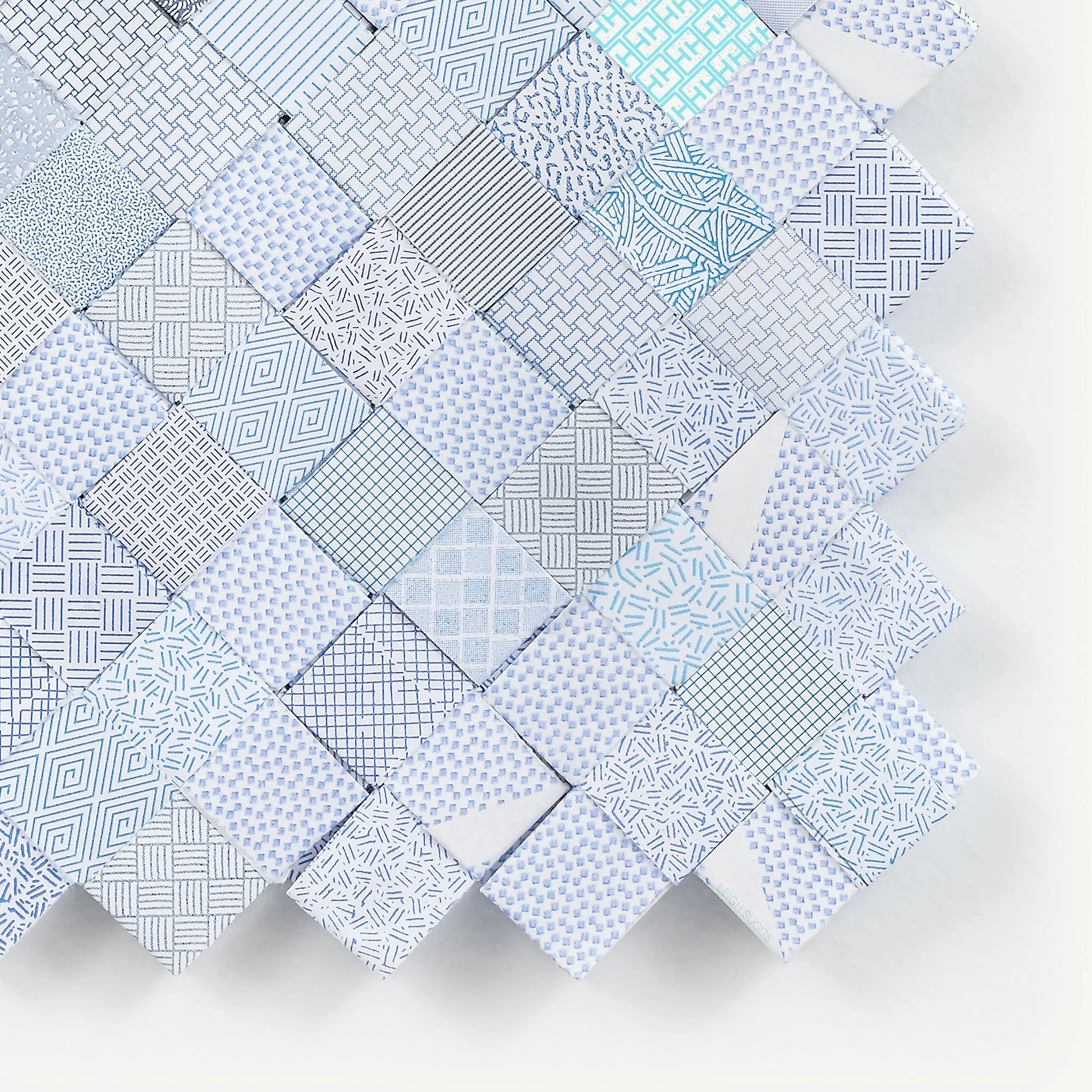 A collection of various blue and white patterned papers arranged in a collage on a light background.