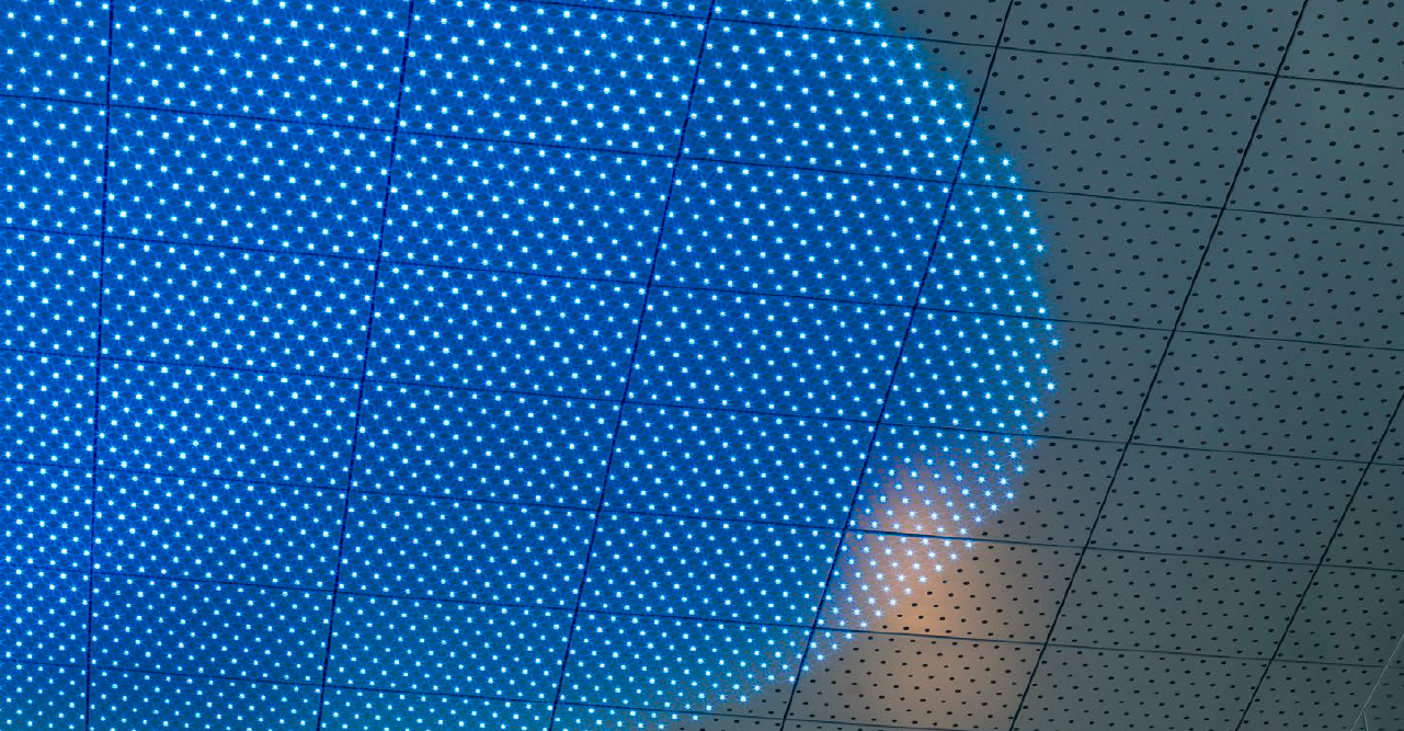 Close-up of a ceiling with a large, circular blue LED light installation.