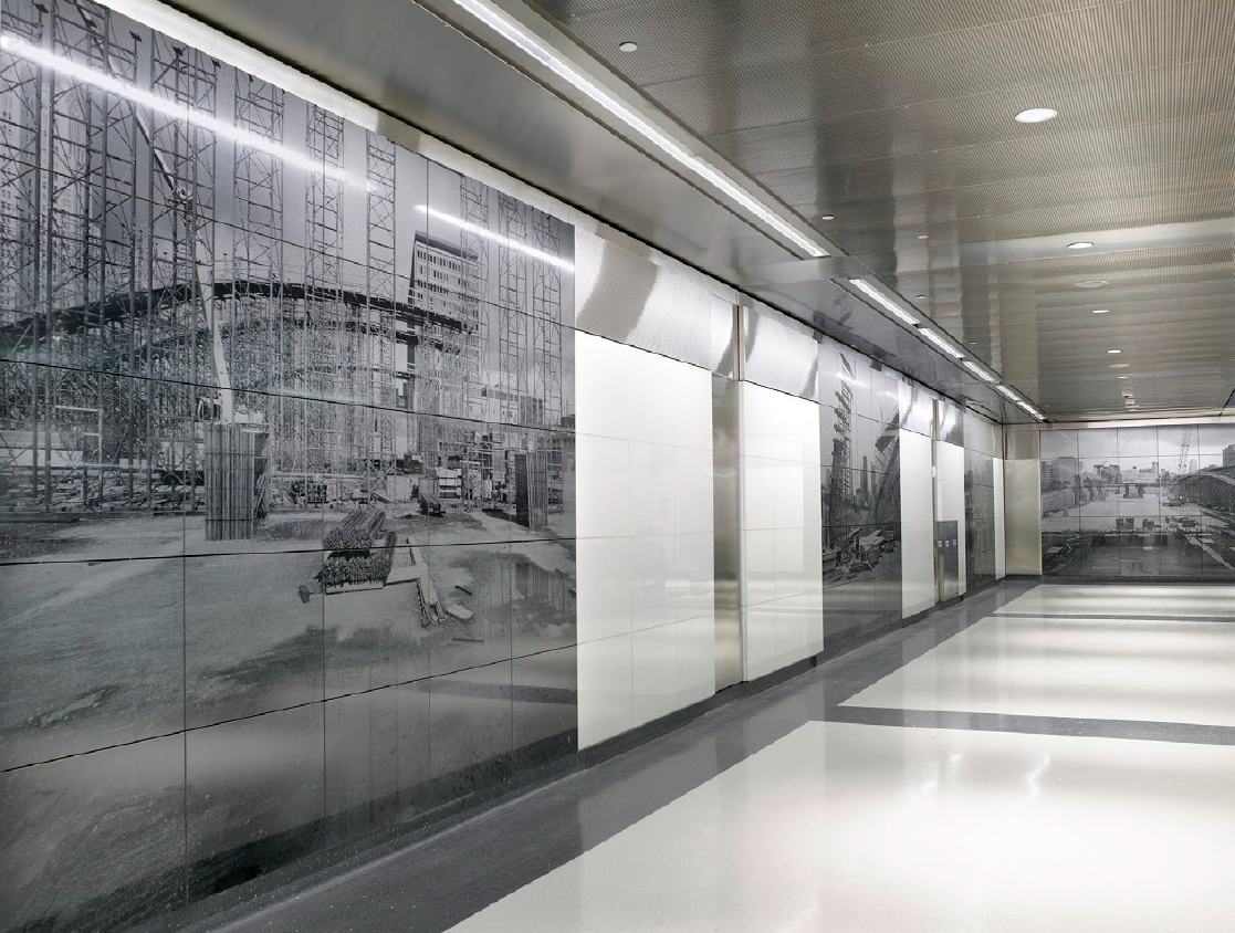 Black and white construction site mural on interior wall in modern building hallway