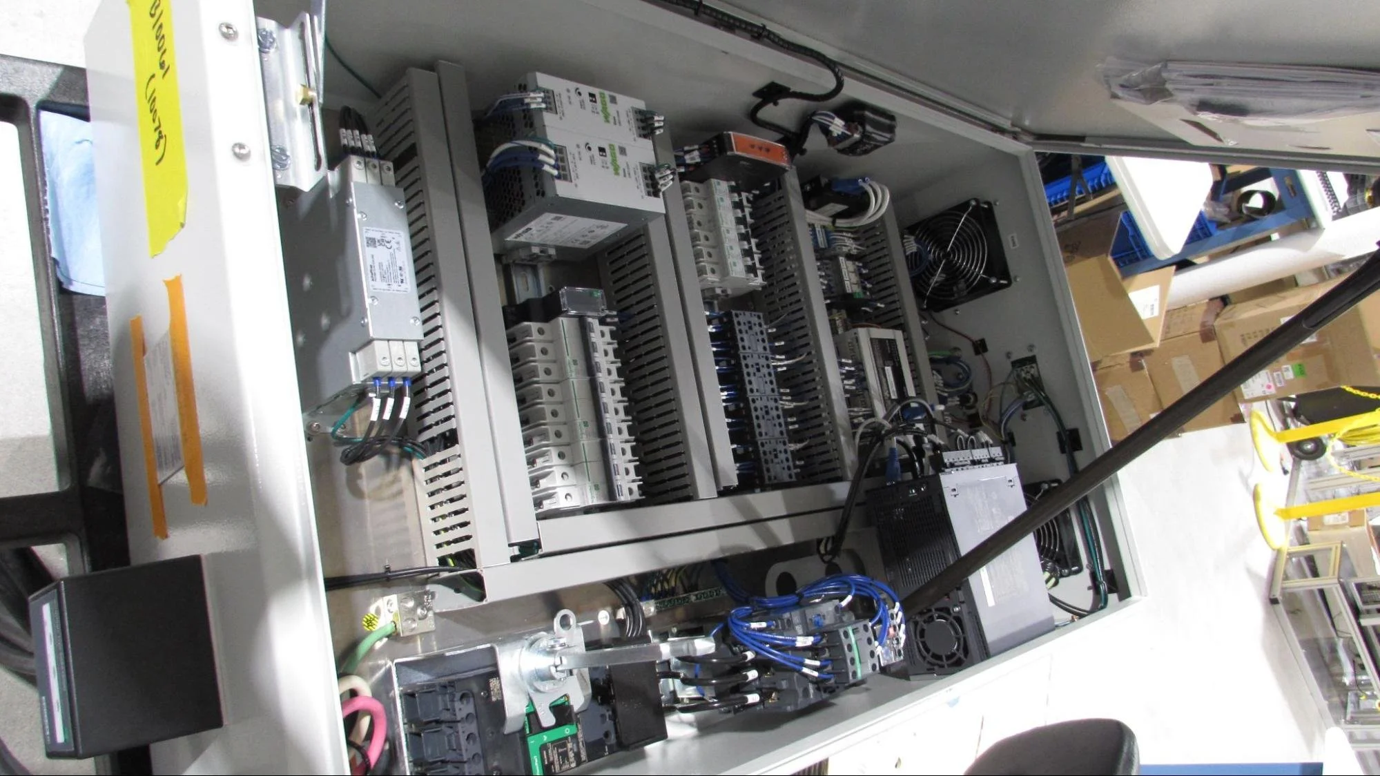 Electrical control panel with various components, wires, and circuit boards inside a metal enclosure.