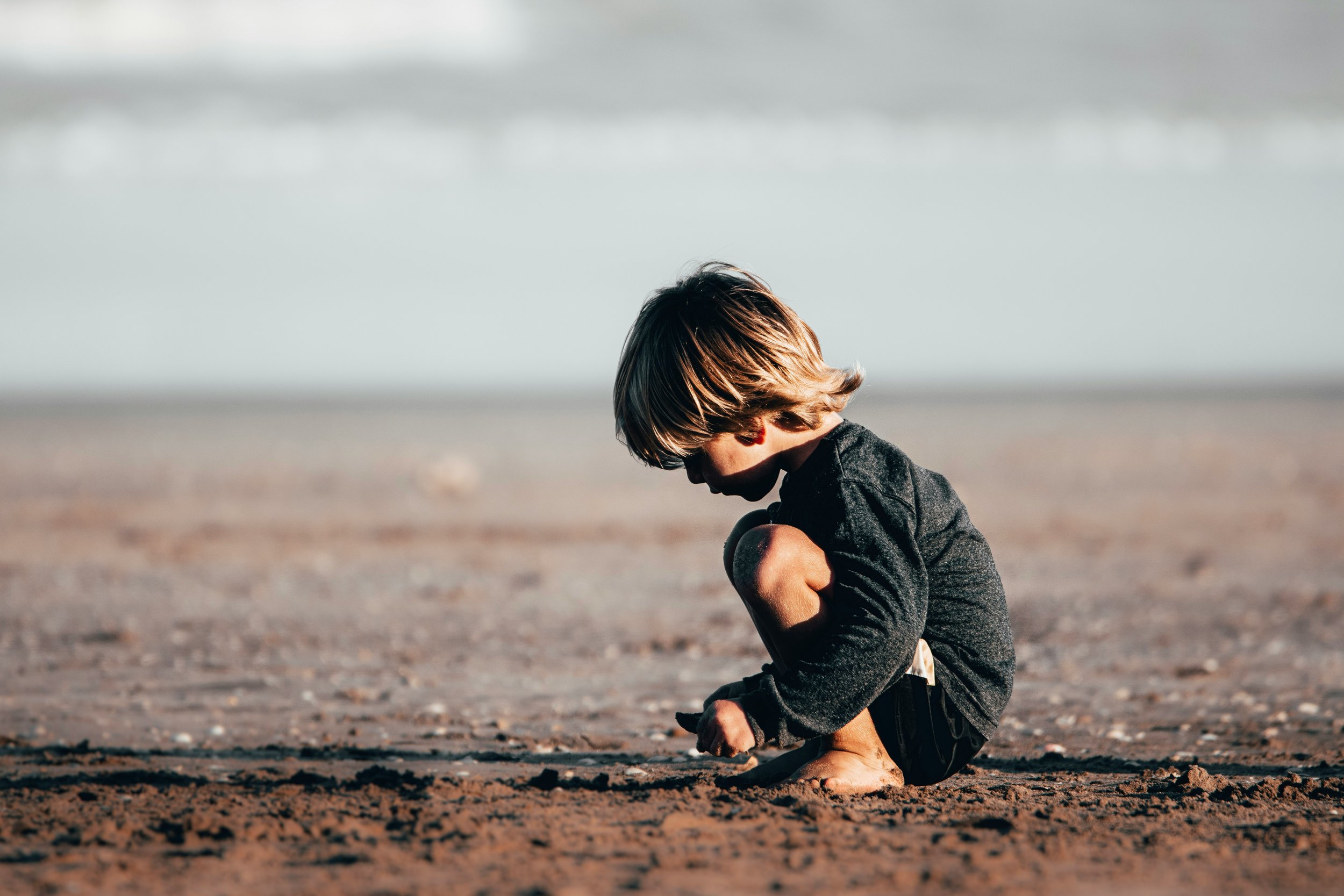 A young boy playing on the beach.