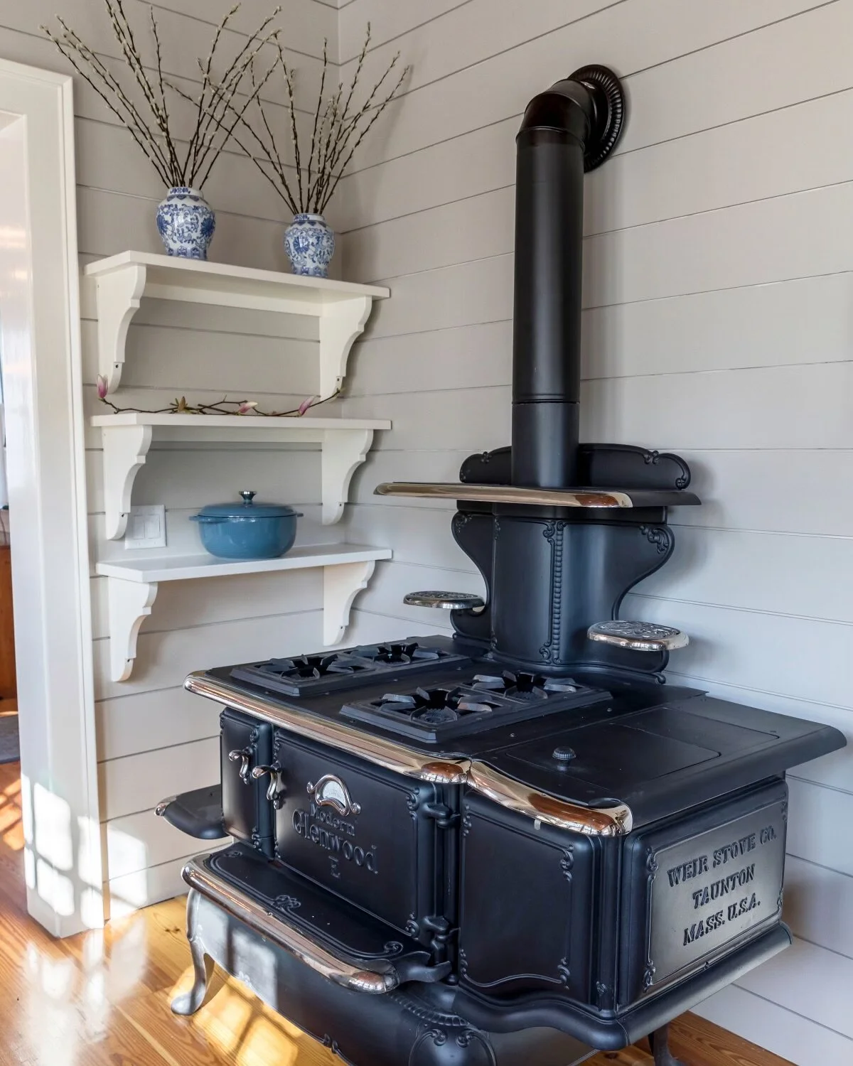 Custom corner shelves in kitchen compliment the old stove that has been converted to natural gas.