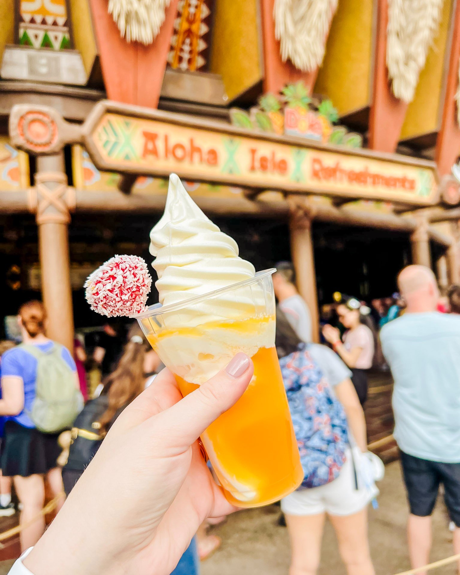 Dole Whip is pretty great, BUT if I'm being honest, my FAVORITE Dole Whip Treat is the Tropical Serenade at Aloha Isle in Magic Kingdom. 
.
It's Coconut Soft-Serve with POG Juice and it's topped with a pineapple upside-down cake pop. The coconut is m