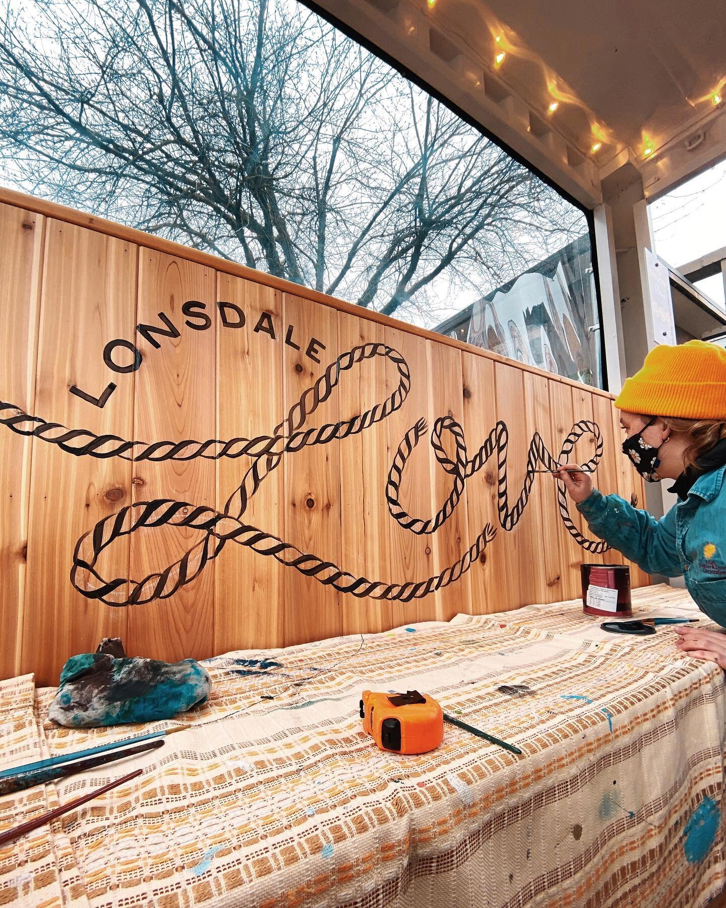 ✨Sunday well spent ✨ #lonsdalelove
.
.
.
[image description: Erica paints the words &ldquo;Lonsdale Love&rdquo; in black on a warm wooden background. The word &ldquo;Lonsdale&rdquo; is shown in all-caps arched above the word &ldquo;Love&rdquo; in cur