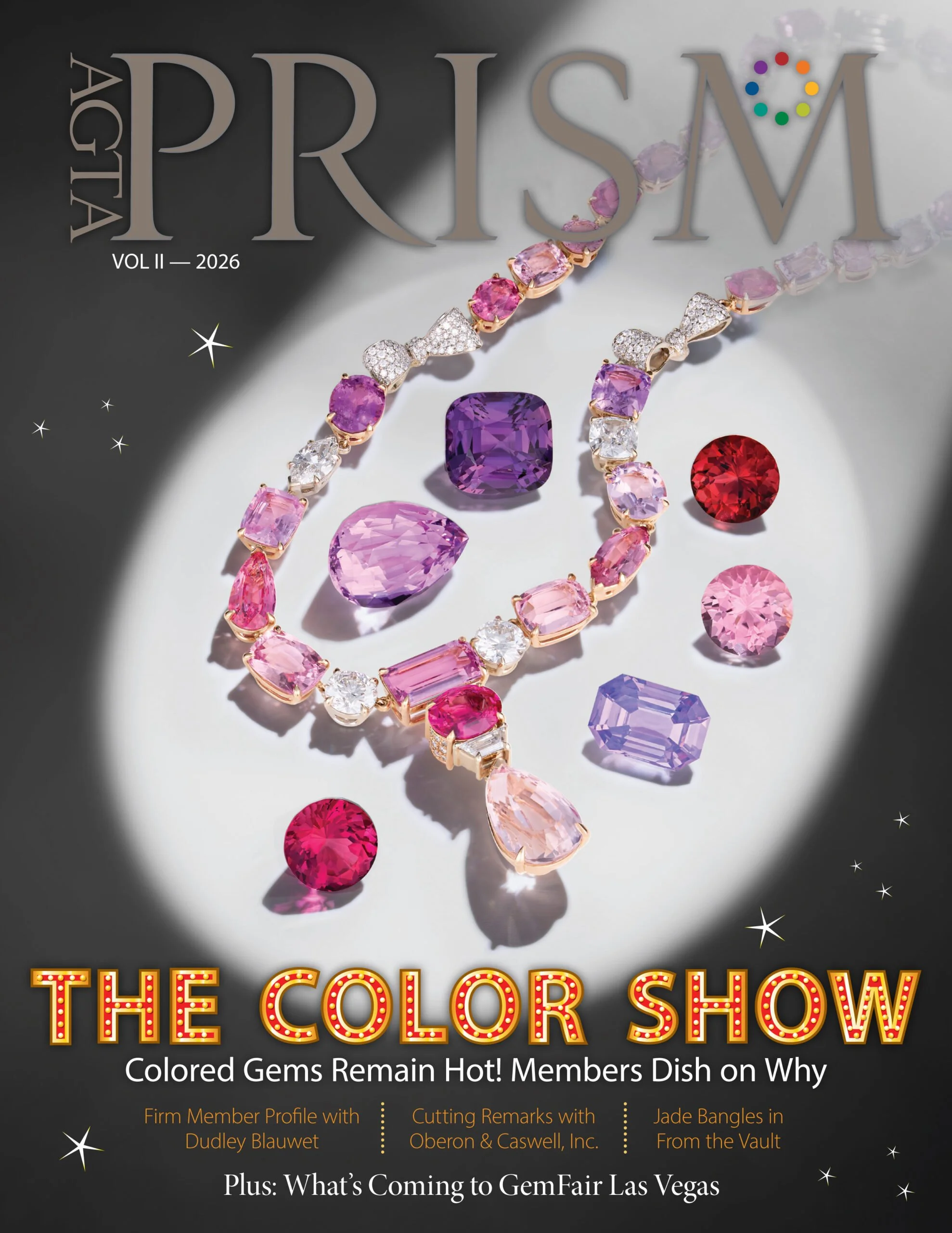 Cover of a magazine titled 'AGTA Prism' Vol. II 2026, featuring a display of various colored gemstones and jewelry pieces, with some text about gem shows and members' profiles.
