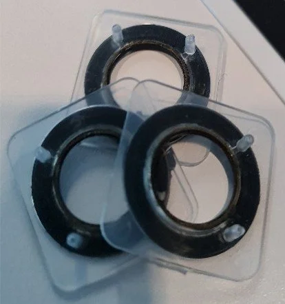 Three 12mm PumpRing disposables on top of each other. The PumpRing is black and the housing has barbed fluid connectors and is transparent