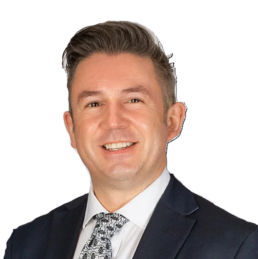 A professional headshot of Jonathan O'Halloran, smiling with short, styled hair, wearing a dark suit, white shirt, and patterned tie, against a plain white background.