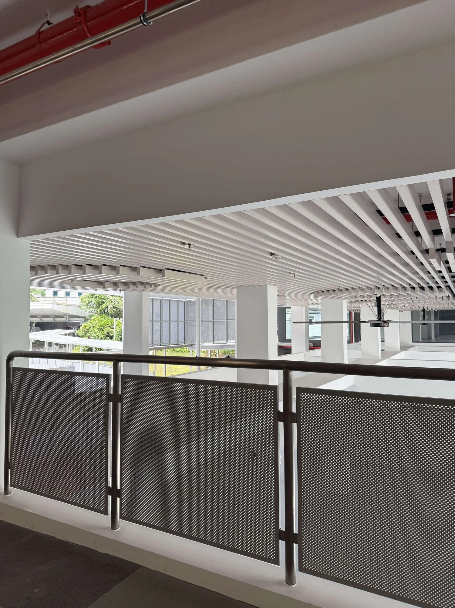 Indoor open space with a metal railing with perforated panels, high quality perforated metal panels with local supplier Supply Bay Singapore. Railing is located in Singapore Polytechnic, one of Singapore's top tertiary schools.
