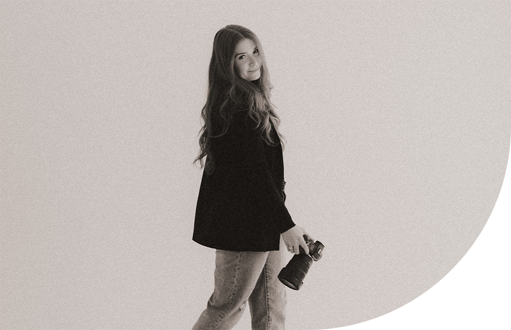 A photographer holding a camera and walking.