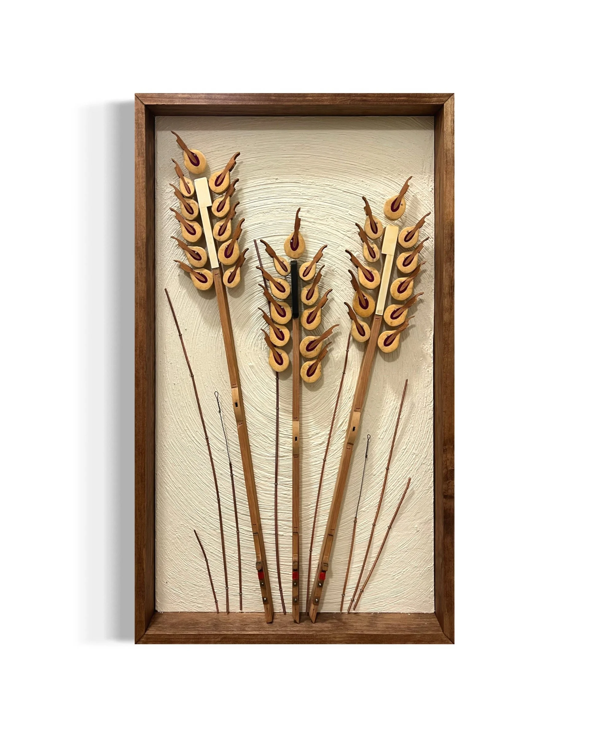 Decorative wall art of 3 wheat stalks made of piano parts.