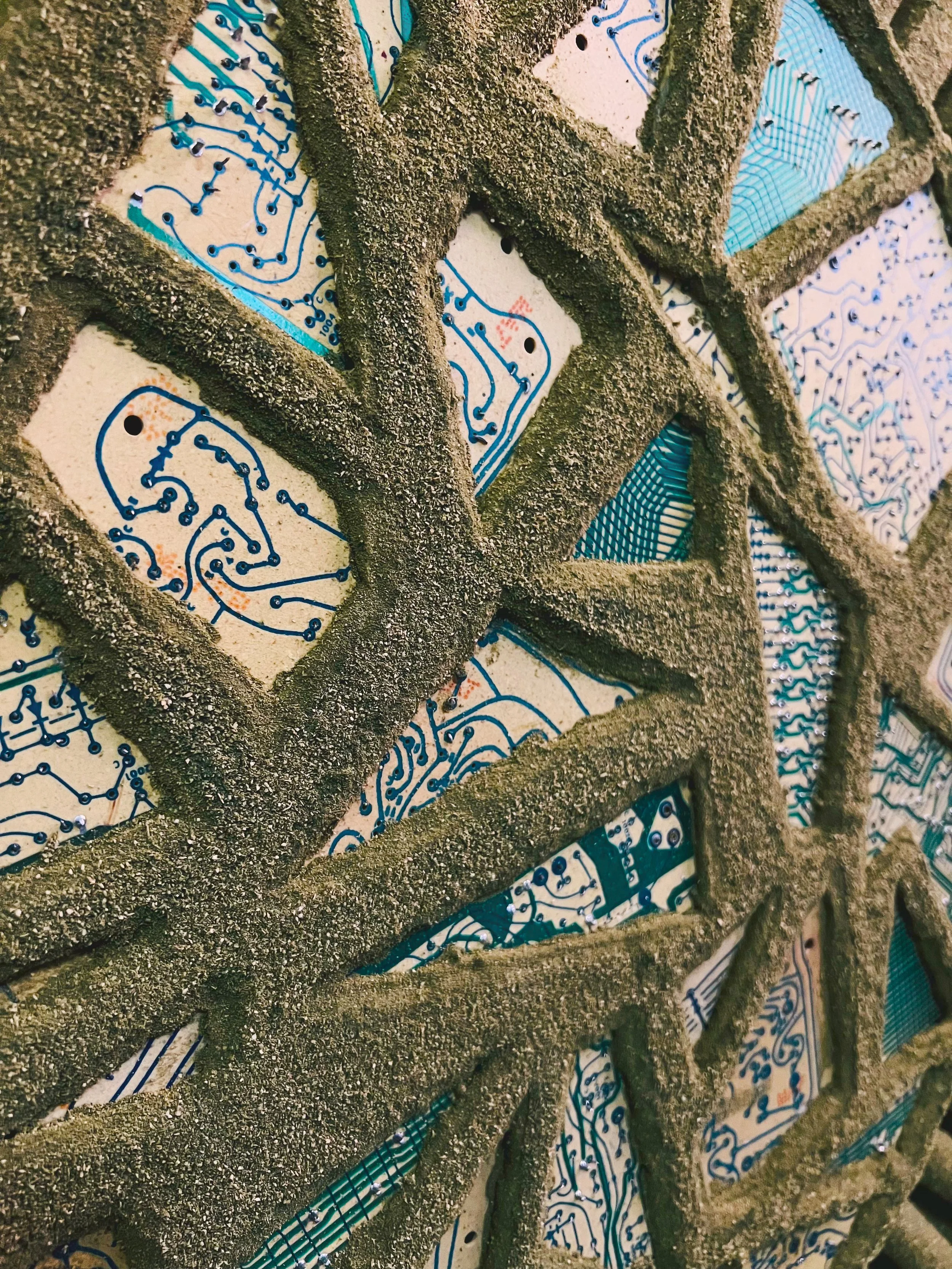 The heart of this piece features circuit boards from an organ, cleared of their electronics. What remains resembles old-world waterways—rivers and canals carved into timeworn terrain.