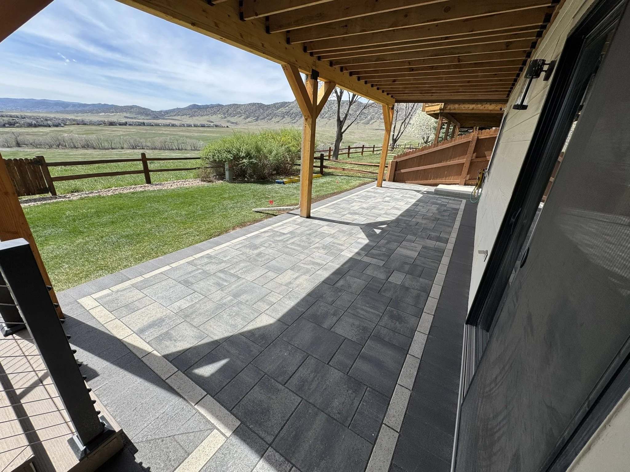 Backyard patio in Littleton, CO featuring a hardscape patio with pavers, covered porch and deck.