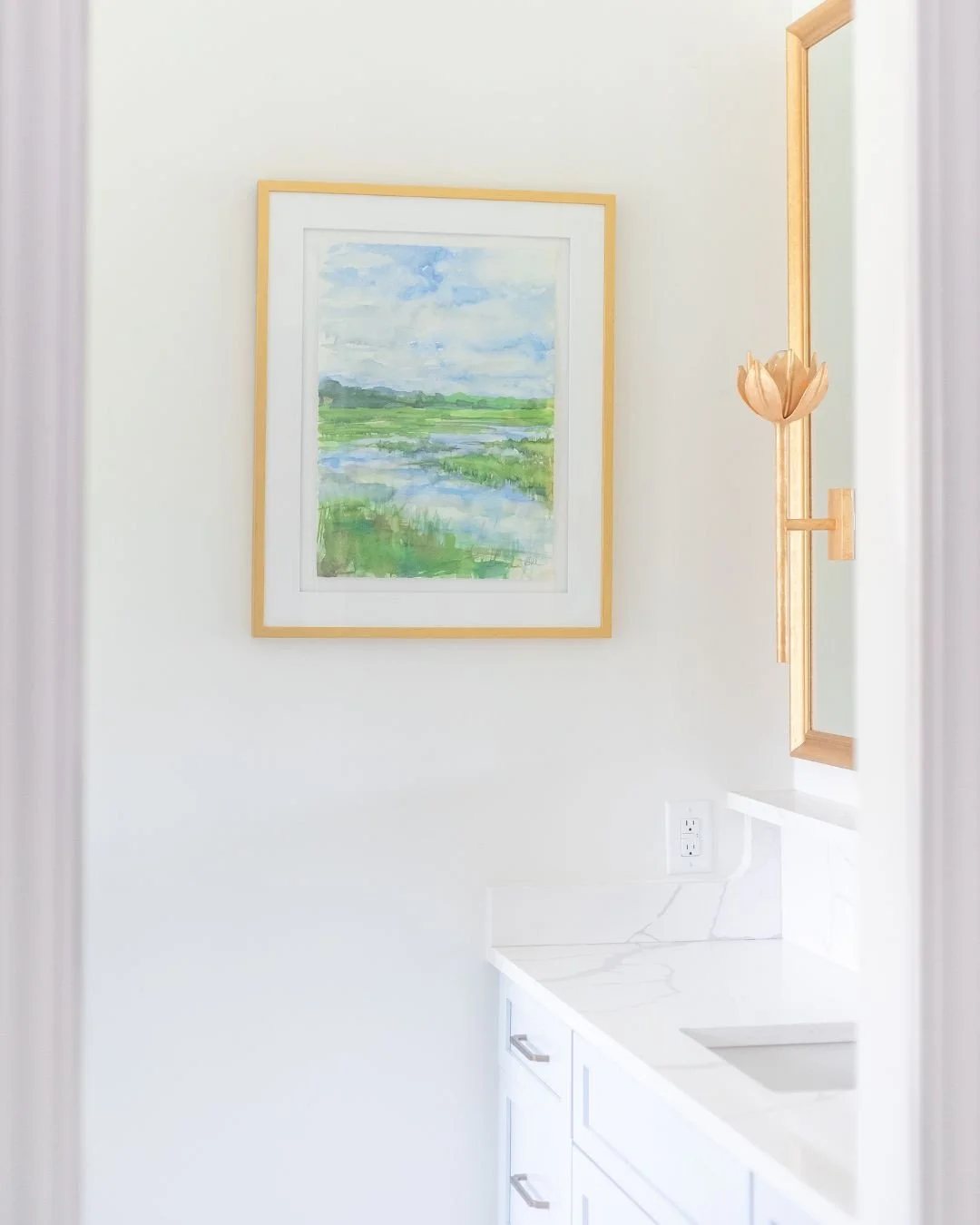Sometimes the finishing touch is the piece that pulls the whole palette together. This marsh landscape was the perfect addition to a bathroom layered with pale blue cabinetry, marble, and warm brass.⁠
⁠
#bathroomdesign #bathroominspo #marble #landsca