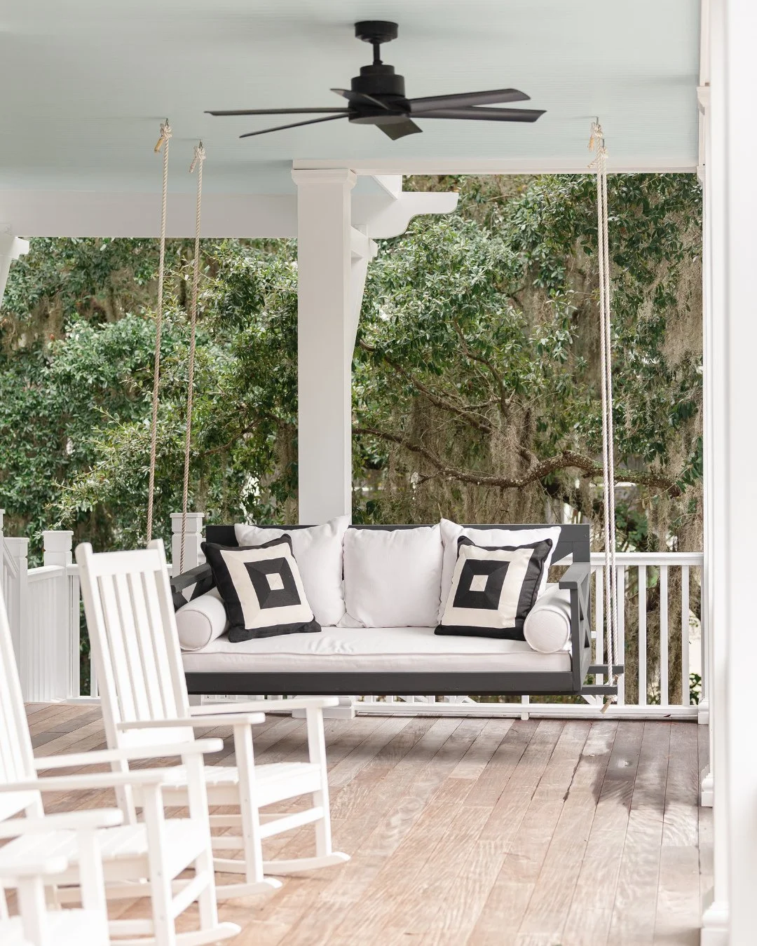 This is what porch swing dreams are made of 🤍 🖤 Timeless black and white with performance fabrics that can take the heat and the humidity.⁠
⁠
#porchinspo #wynnepeaceinteriordesign #porchswing #southernstyle