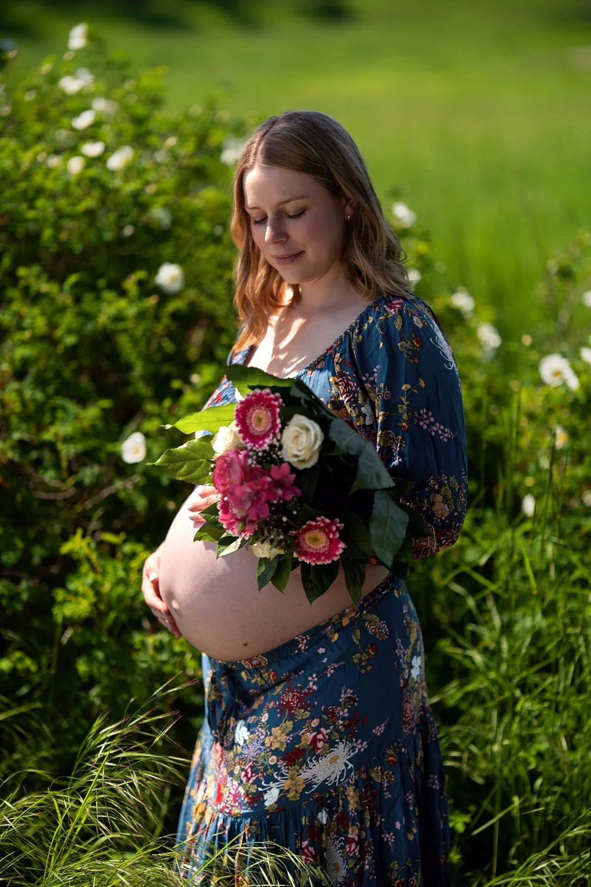Babybauch Fotografie in Berlin und Brandenburg zeigt eine Schwangere mit Blumenstrauß