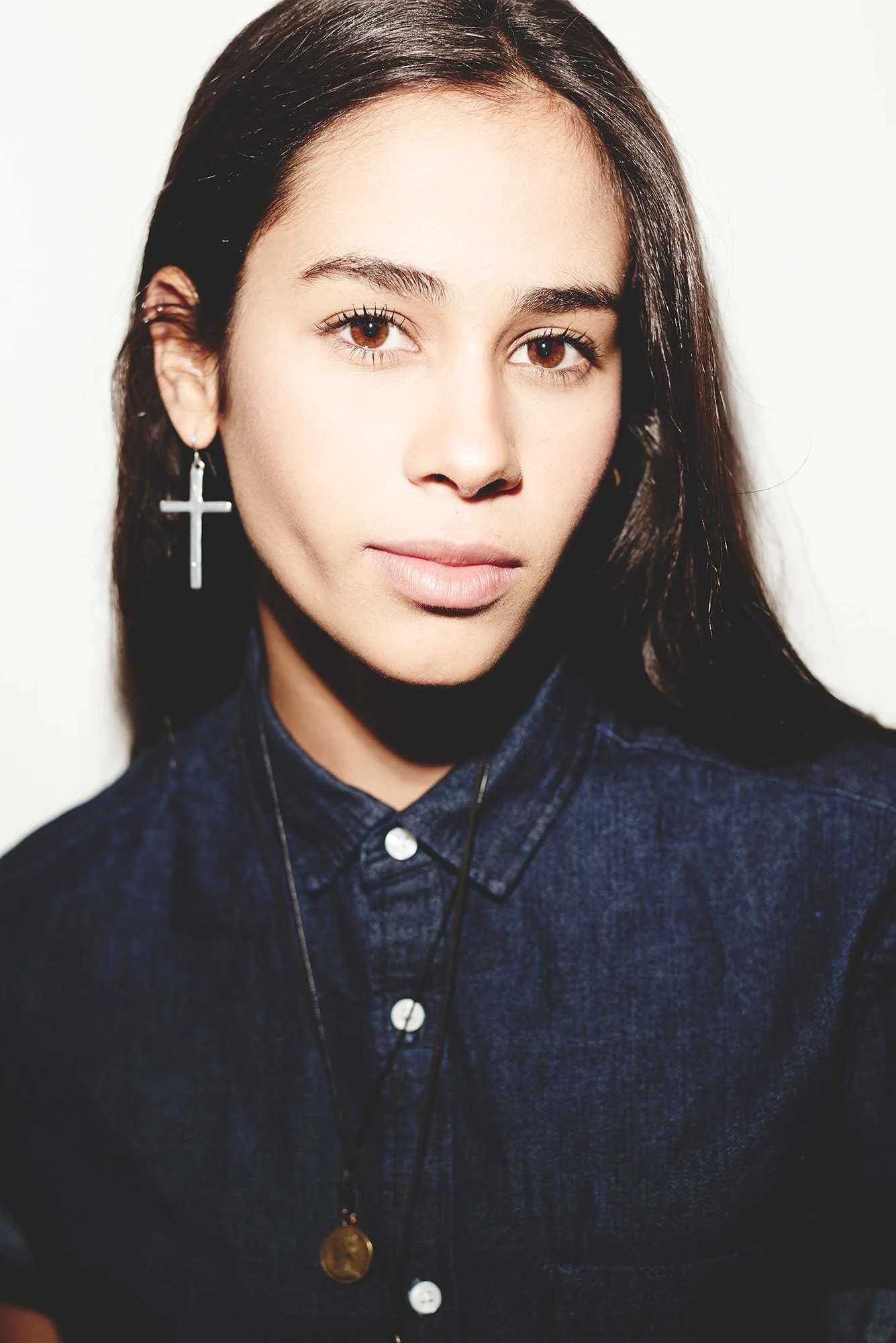 Eine junge Latina mit einem Kruzifix als Ohrring