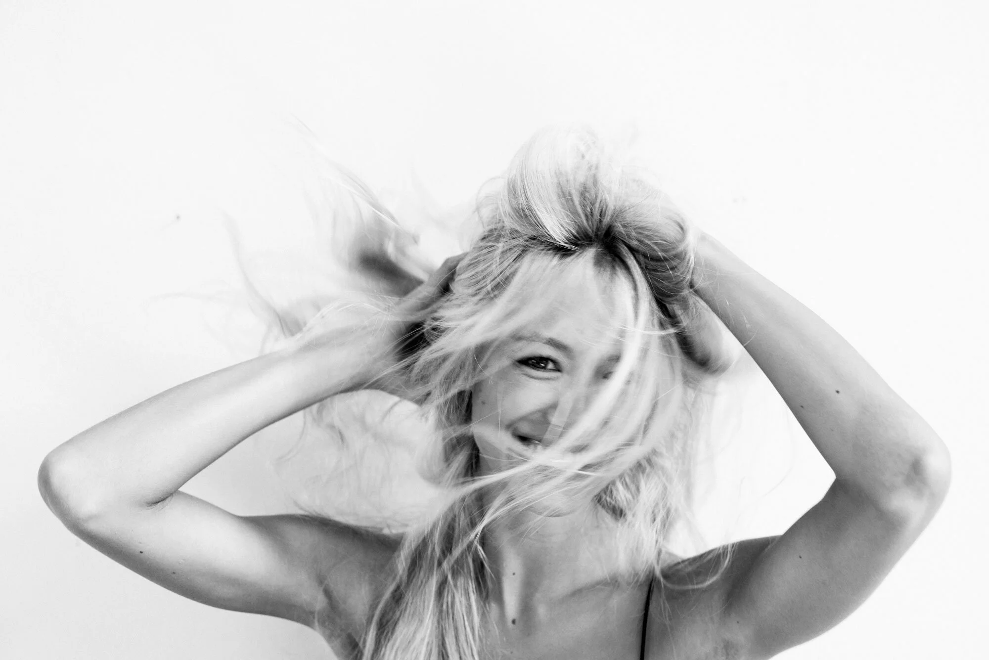 Eine blonde Frau wuschelt sich in den Haaren