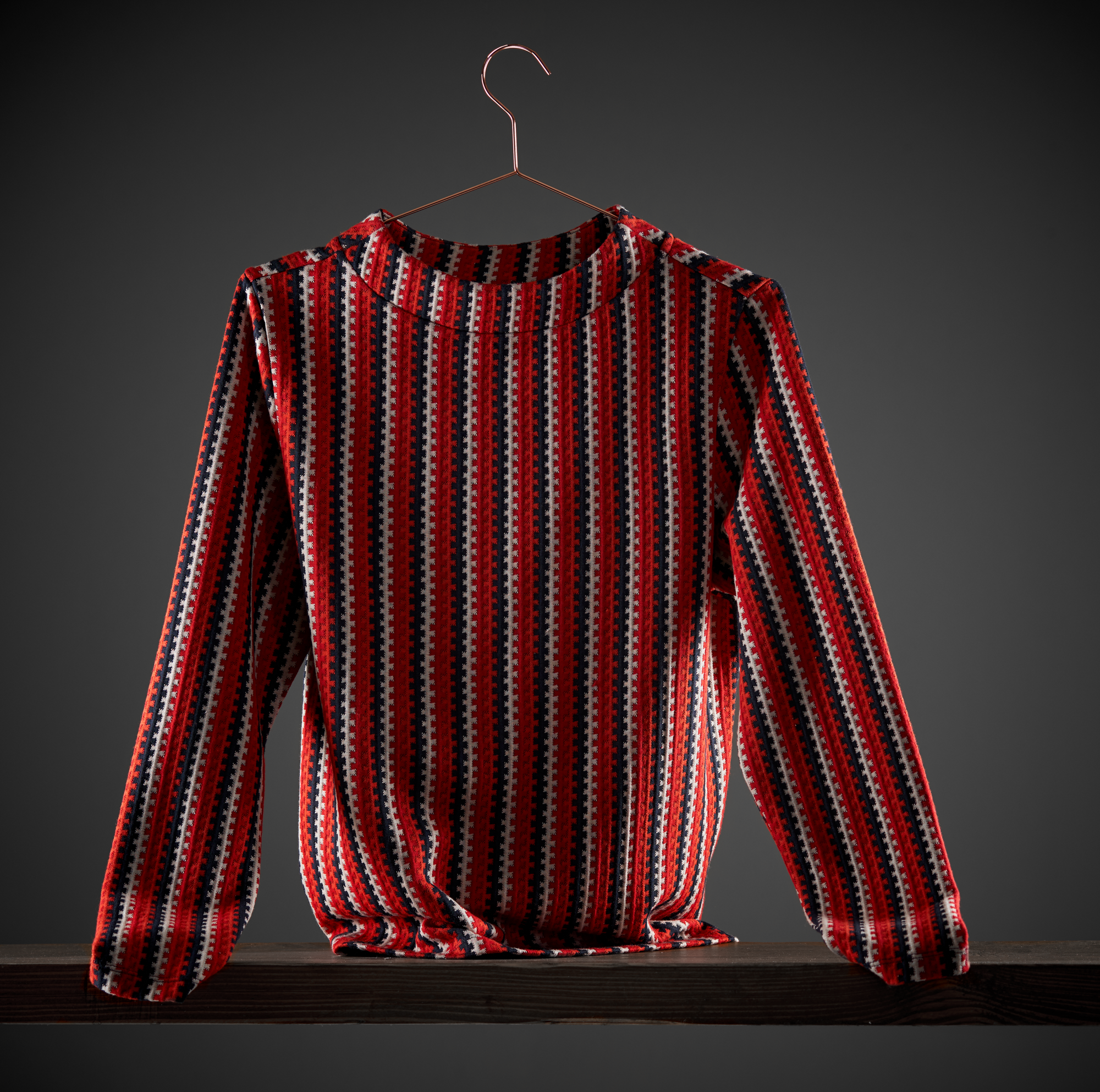 Ein hochwertiges Still Foto eines gestreiften Damen Pullovers in sehr artifiziellem Licht