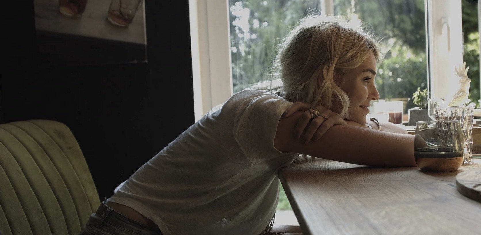 Louisa Hartema sitzt lächelnd am Küchentisch