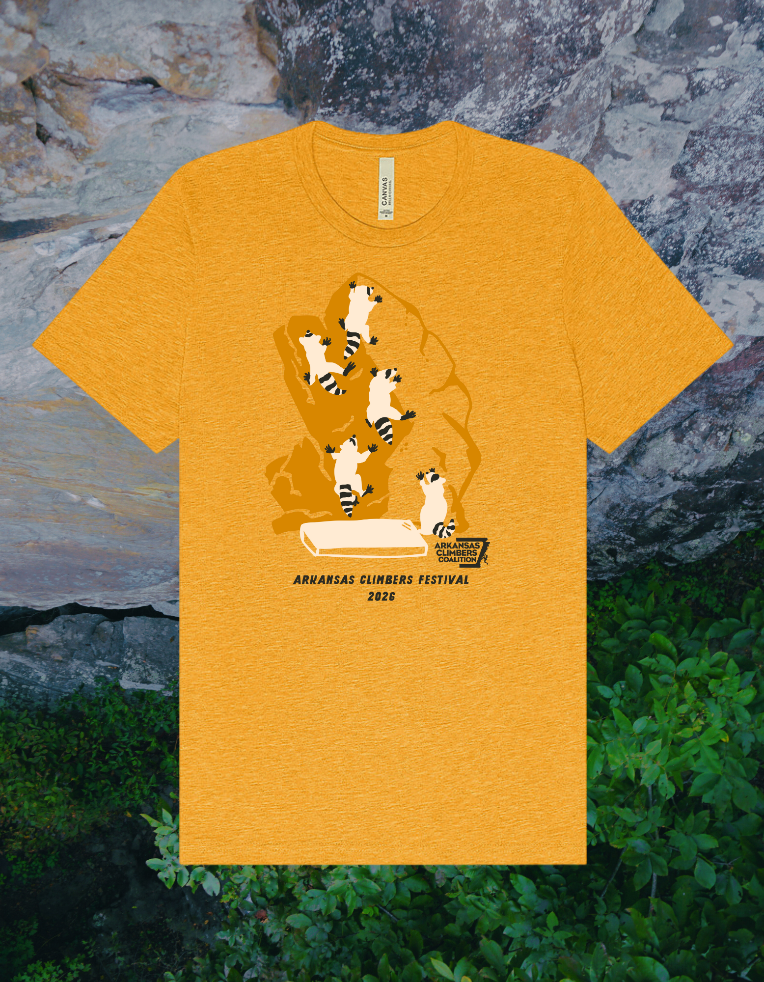 Orange T-shirt with a graphic design featuring five cartoon lemurs climbing on a rock formation, text reading "Arkansas Climbers Coalition," "Arkansas Climbers Festival 2026," and a small climbing mat at the bottom.