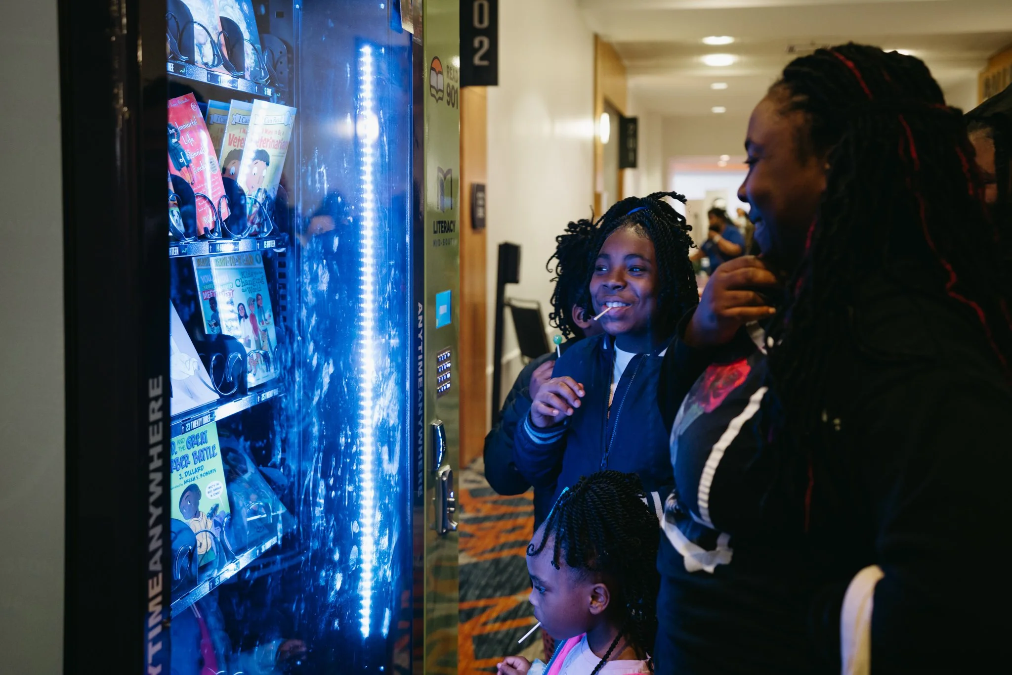 A family looking at the book vending machine at the Right to Read film screening event at the Renasant Convention Center, Memphis.