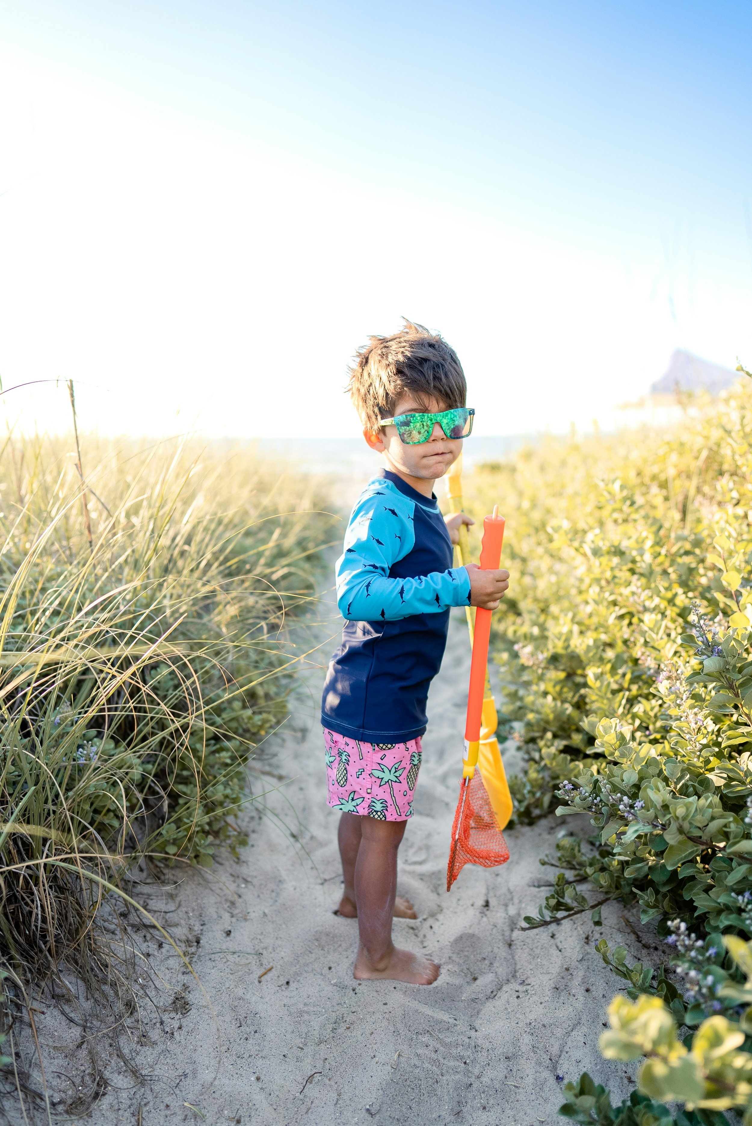 Kid with glasses at the beach and he has separation anxiety.